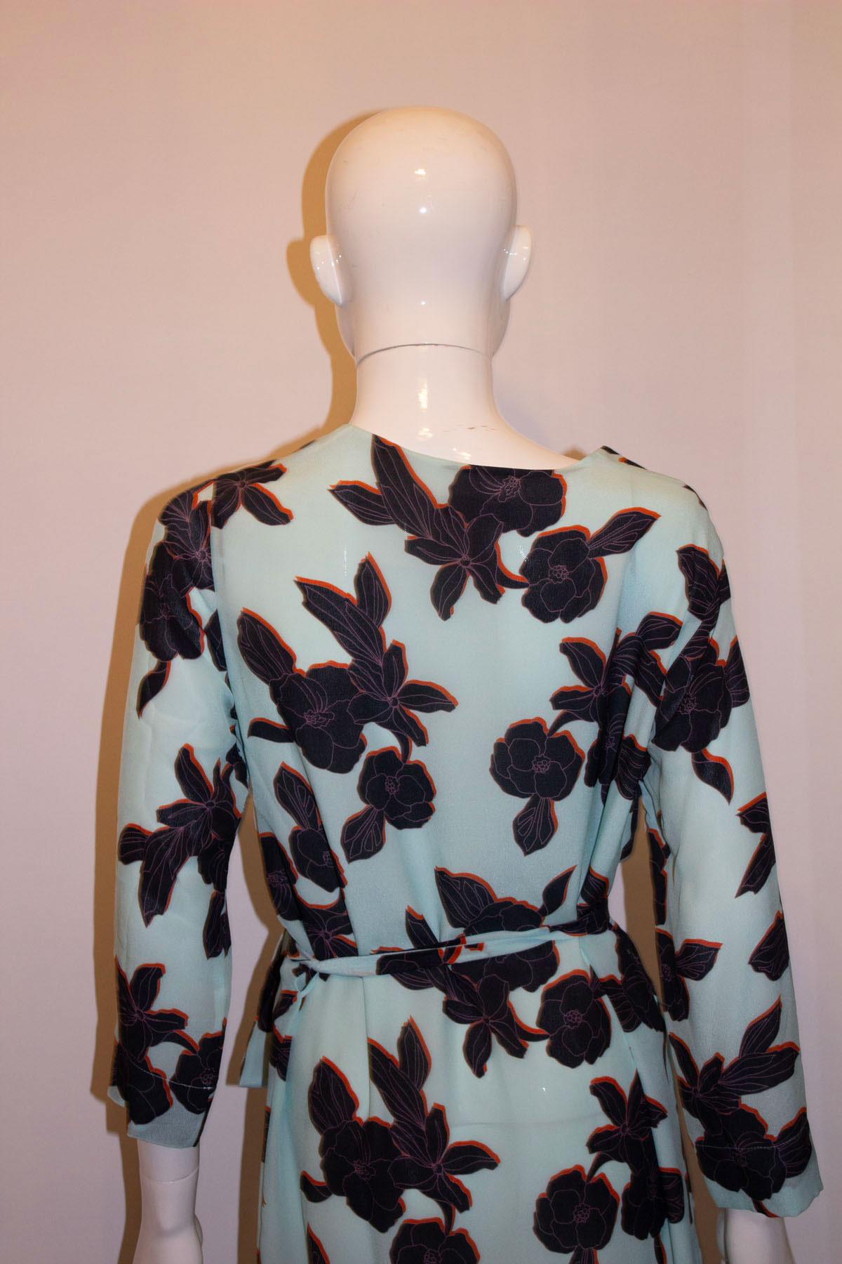 A pretty silk dress by British designer Paul Smith , Black label range. The dress has a turquoise back ground with a navy and rust colour print. It is fully lined, has a v neckline and a self fabric belt. 
Size EU , Italian 44 Measurements Bust up