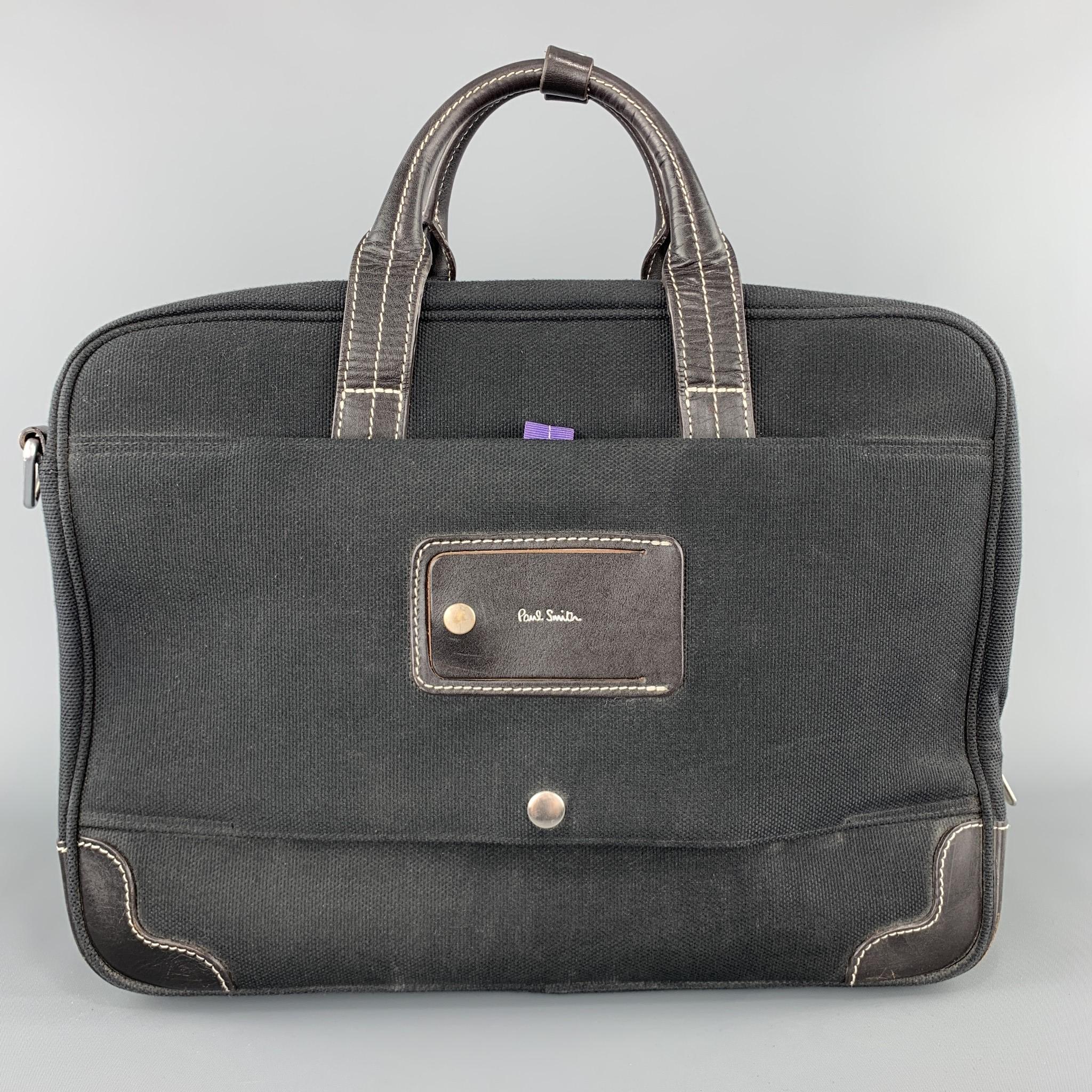 PAL SMITH work bag comes in black canvas with black leather trim, contrast stitching, double top handles, detachable strap, and purple multi-compartment interior. 

Good Pre-Owned Condition.

Measurements:

Length: 15.5 in.
Width: 6 in.
Height: 12