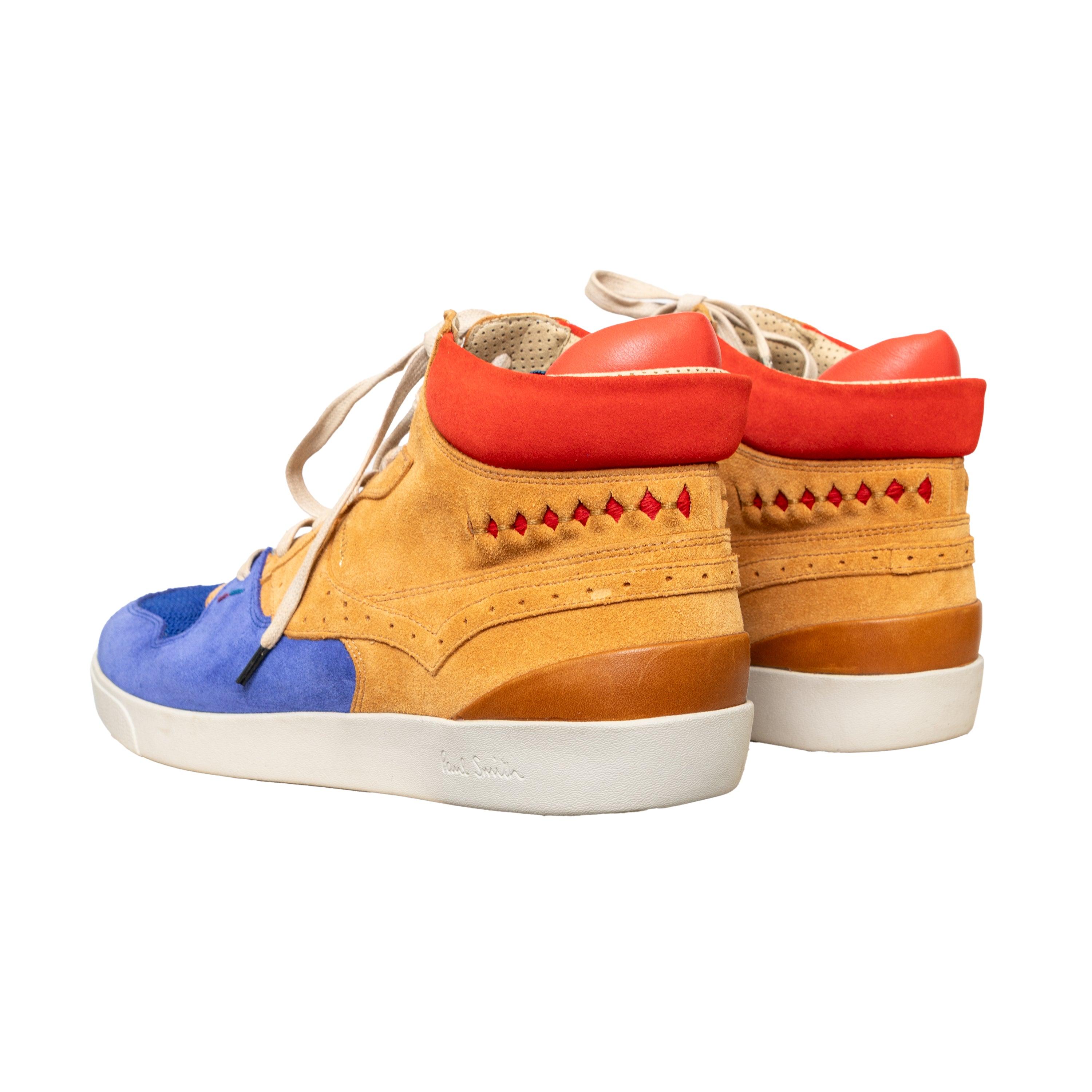 Le sneakers Paul Smith del marchio Jeans, in materiale scamosciato, presentano un design high-top con un motivo colorblock in marrone chiaro, blu e rosso, accentuato da dettagli traforati e mesh.
 Inclusione: sacchetto antipolvere. 
 Misure: