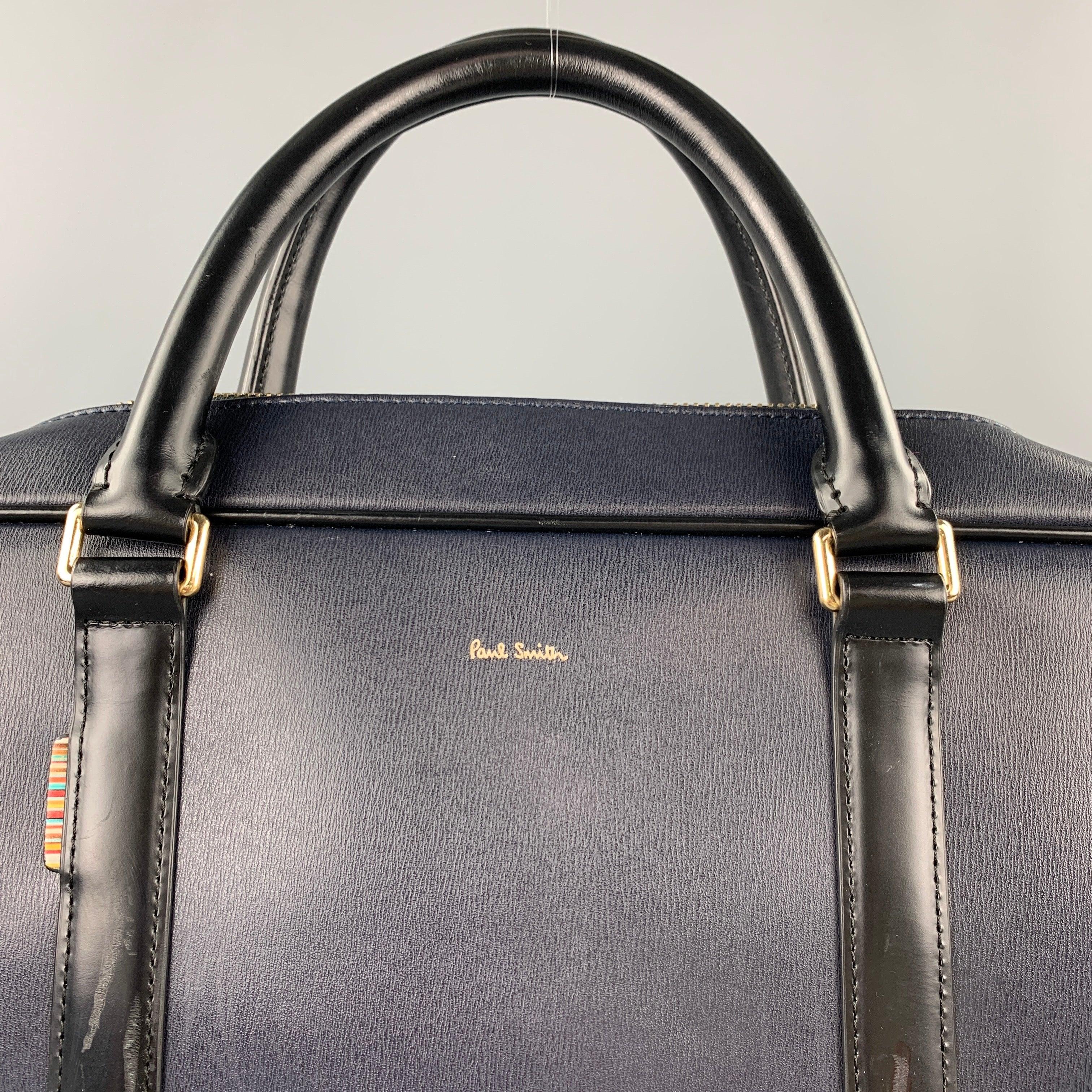 PAUL SMITH briefcase bag comes in a navy & black leather featuring a shoulder strap, top handles, gold tone hardware, inner slots, and a zip up closure. Moderate wear.Good
Pre-Owned Condition. 

Measurements: 
  Length: 15 inches  Width: 3.5 inches 
