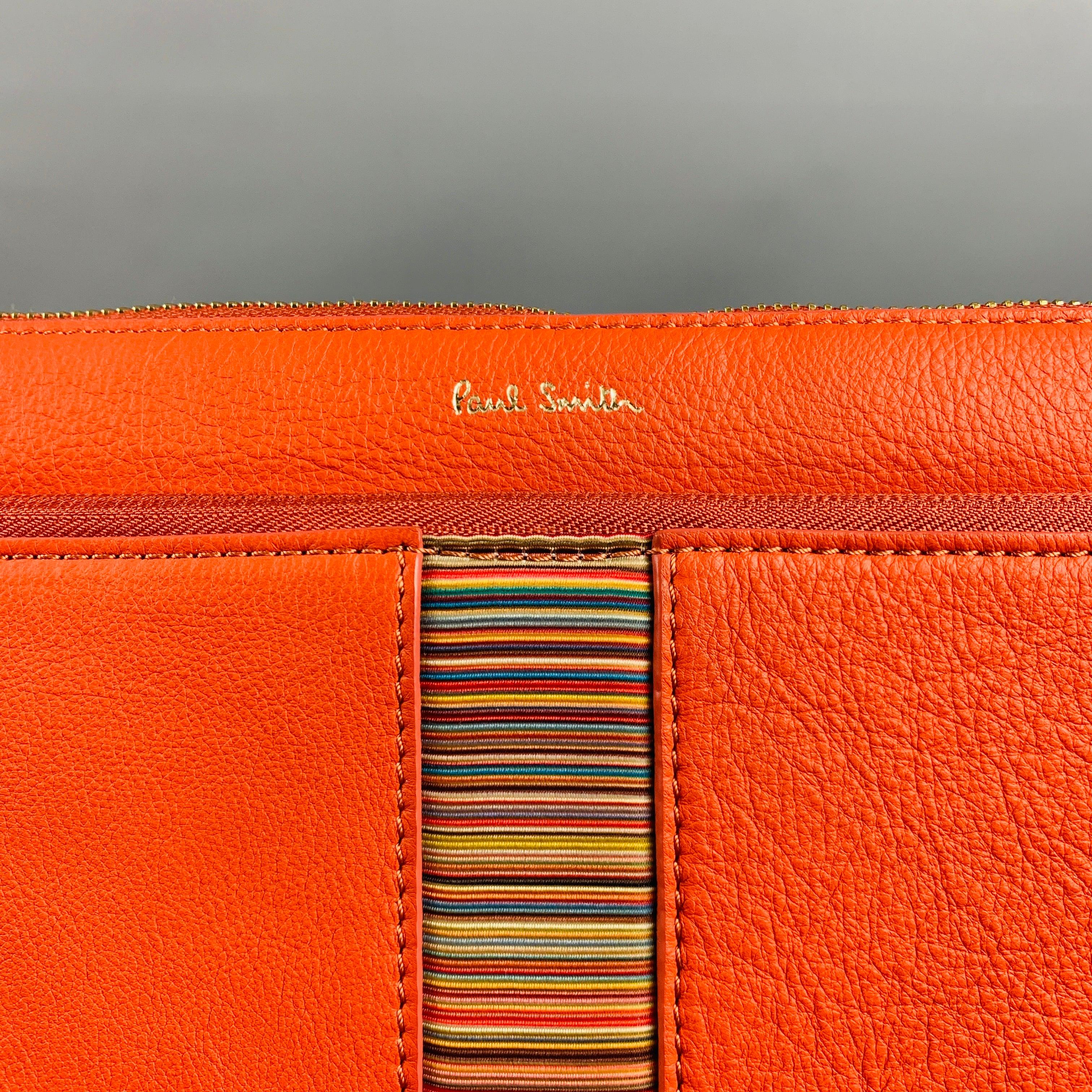 PAUL SMITH document holder case comes in orange leather with a leather strap holder, inner zipper pocket, inner slots and canvas interior. New with Tags.14 x 10.5 inches 
  
  
 
Reference No.: 129224
Category: Bags & Leather Goods
More Details
   