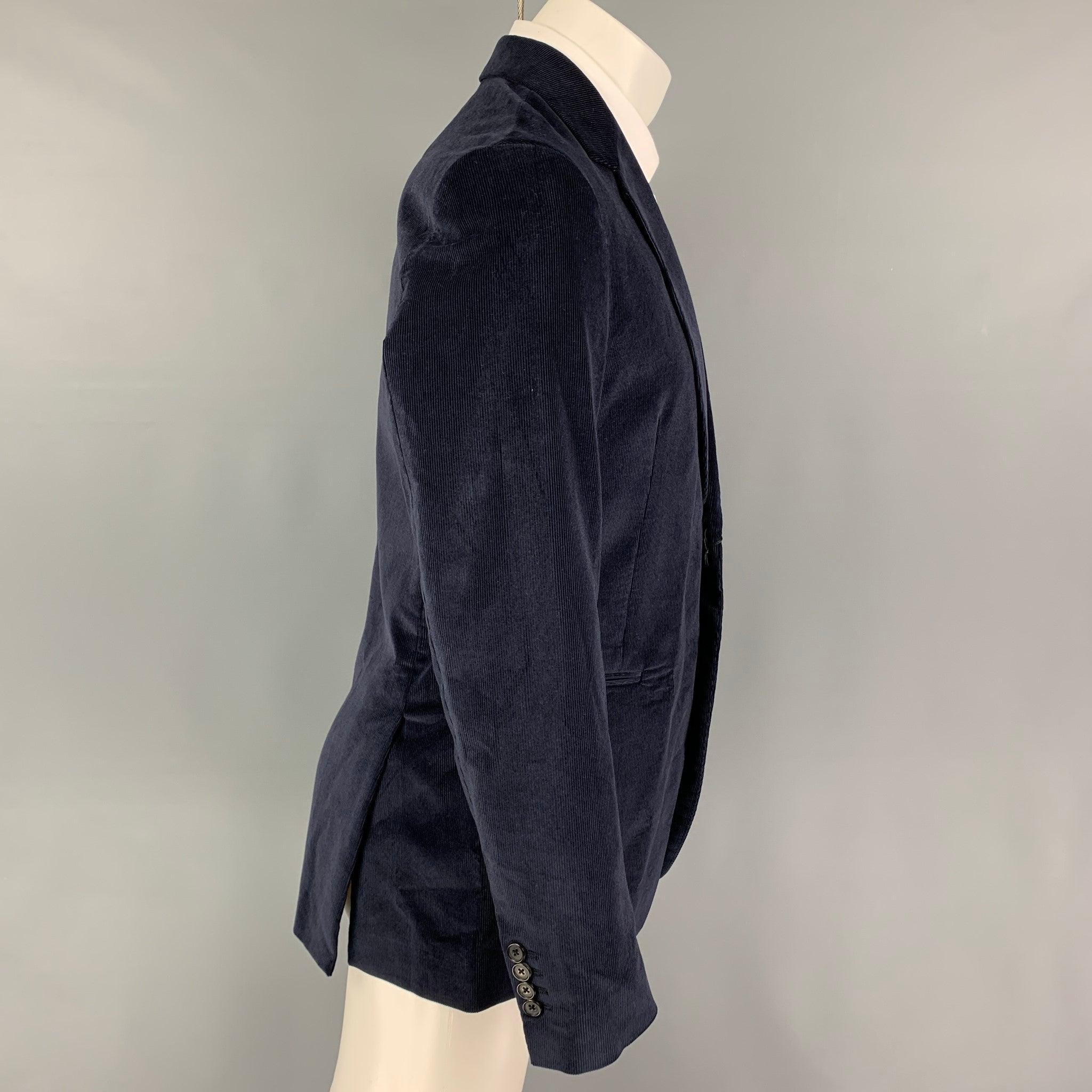 PAUL SMITH sport coat comes in a navy corduroy cotton with a full liner featuring a notch lapel, slit pockets, double back vent, and a double button closure. Made in Italy. New with tags.  

Marked:   38 

Measurements: 
 
Shoulder: 17.5 inches
