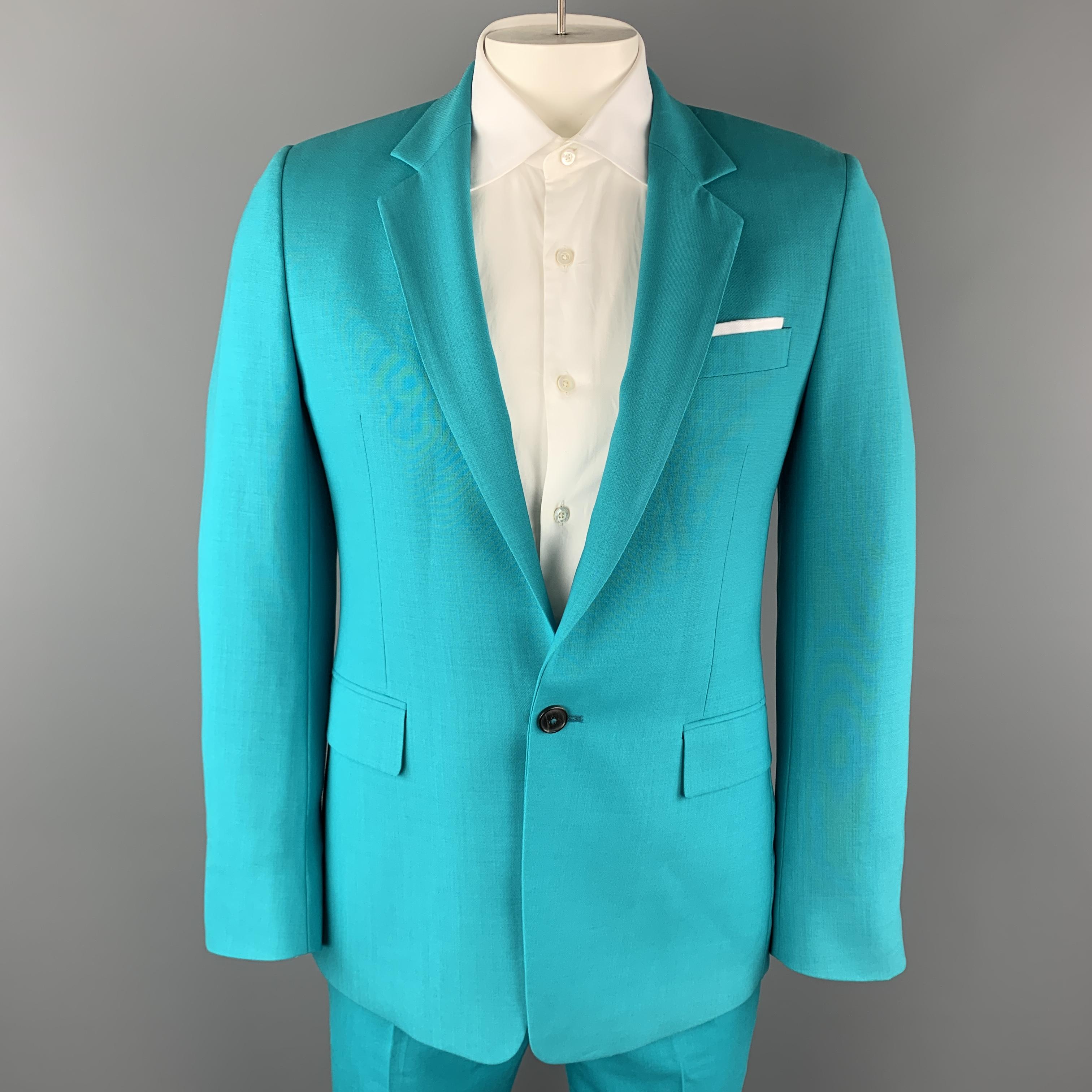 DREAMER PAUL SMITH suit comes bold aqua green wool in and includes a single breasted, functional button cuff, one button sport coat with a notch lapel and white mock pocket square, with matching flat front trousers. Made in Italy.

Excellent