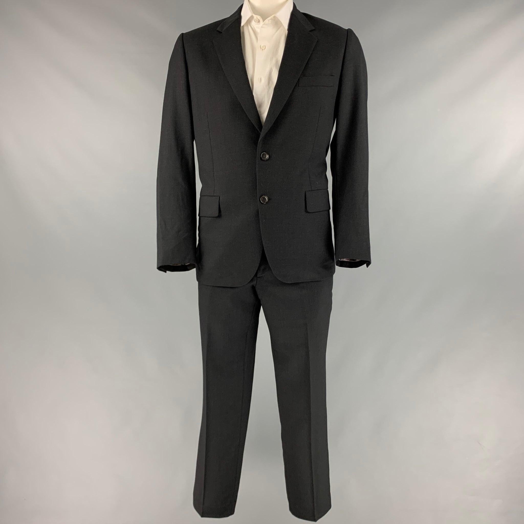 PAUL SMITH suit
in a black wool with a full liner and includes a single breasted, double button sport coat with notch lapel and matching flat front trousers. Made in Italy.Very Good Pre-Owned Condition.
Minor signs of wear. 

Marked:   42R
