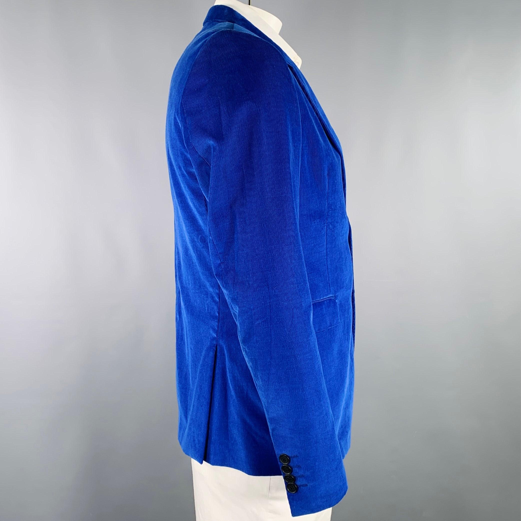Manteau de sport PAUL SMITH
en velours côtelé de coton bleu bijou, avec un revers échancré, un dos doublement ventilé et une fermeture à double bouton. Fabriqué en Italie. Très bon état. Petite marque difficile à voir sur le revers, petites
