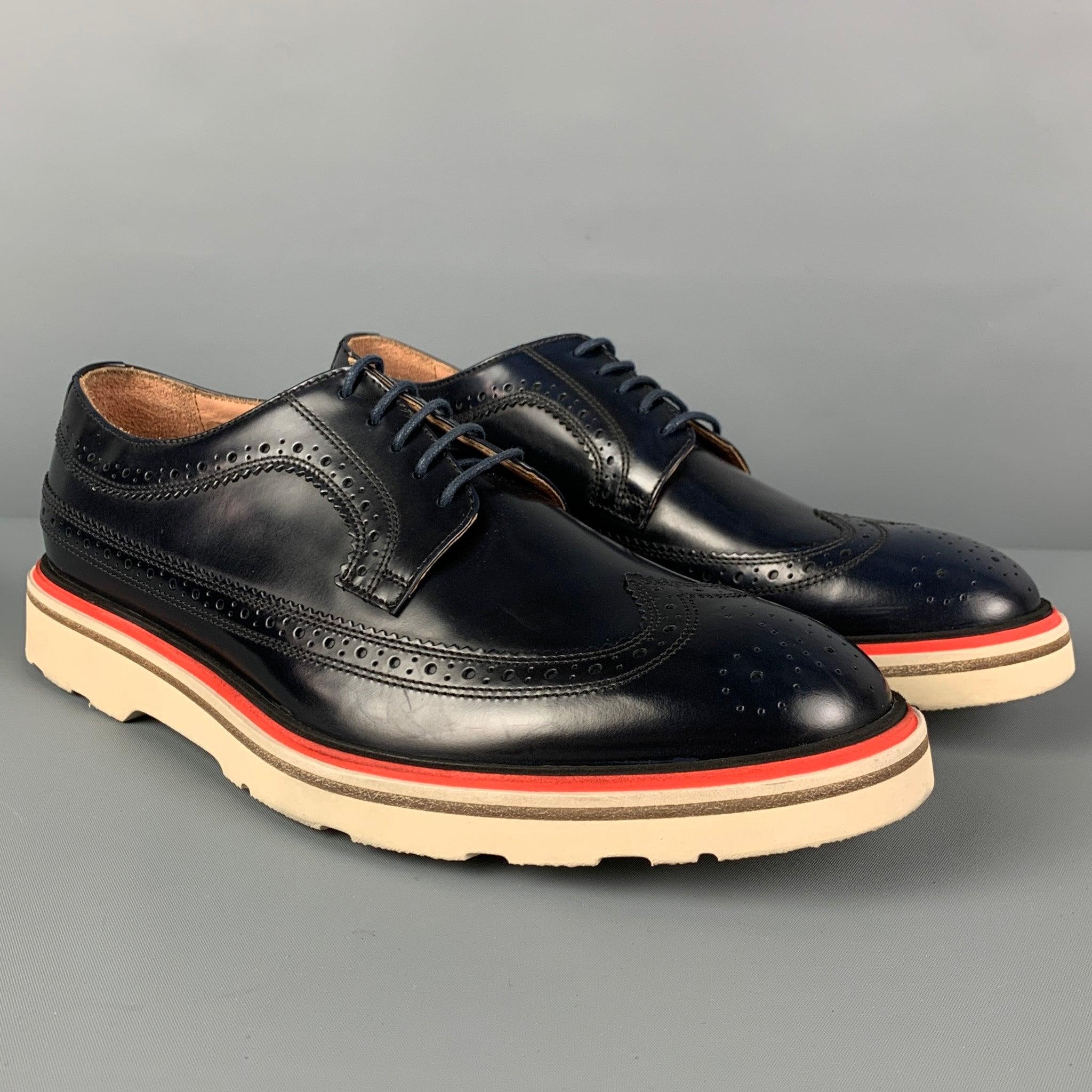 PAUL SMITH shoes comes in a navy & white perforated leather featuring a wingtip style and a lace up closure. Comes with boX. Made in Italy. Very Good
Pre-Owned Condition. 

Marked:   6.5Outsole:11.5 inches  x 4.5 inches 
  
  
 
Reference: