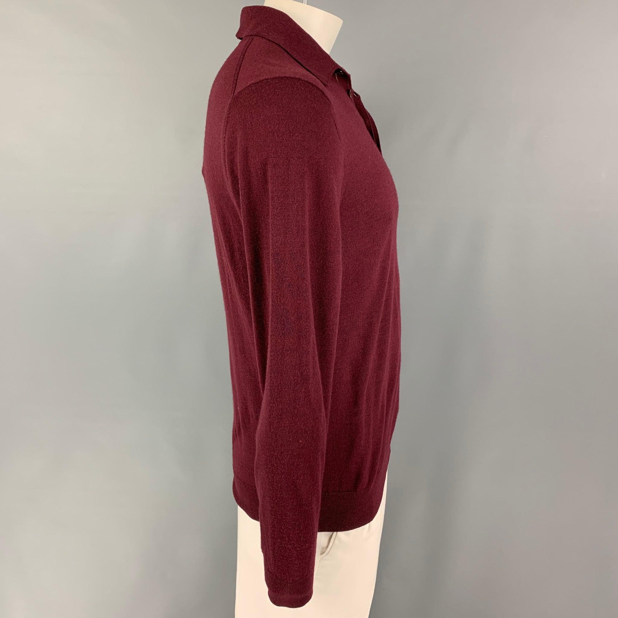 PAUL SMITH polo comes in a burgundy merino wool featuring long sleeves, spread collar, and a hidden buttoned closure.
Very Good
Pre-Owned Condition. 

Marked:   L  

Measurements: 
 
Shoulder: 19 inches Chest: 40 inches Sleeve: 27 inches Length: