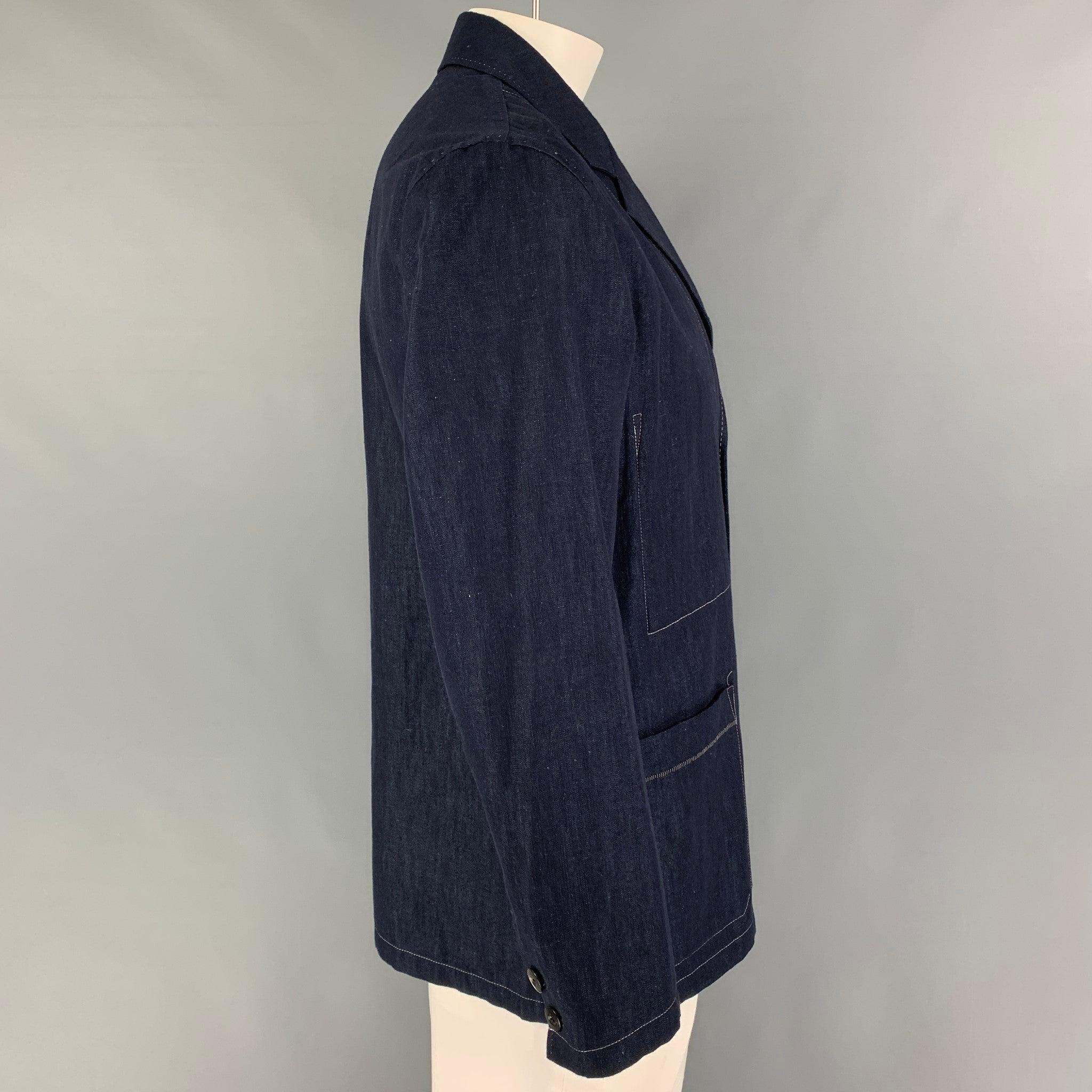 PAUL SMITH sport coat comes in a indigo cotton blend featuring a notch lapel, patch pockets, contrast stitching, and a buttoned closure.
Very Good
Pre-Owned Condition. 

Marked:   L  

Measurements: 
 
Shoulder: 18.5 inches Chest: 44 inches