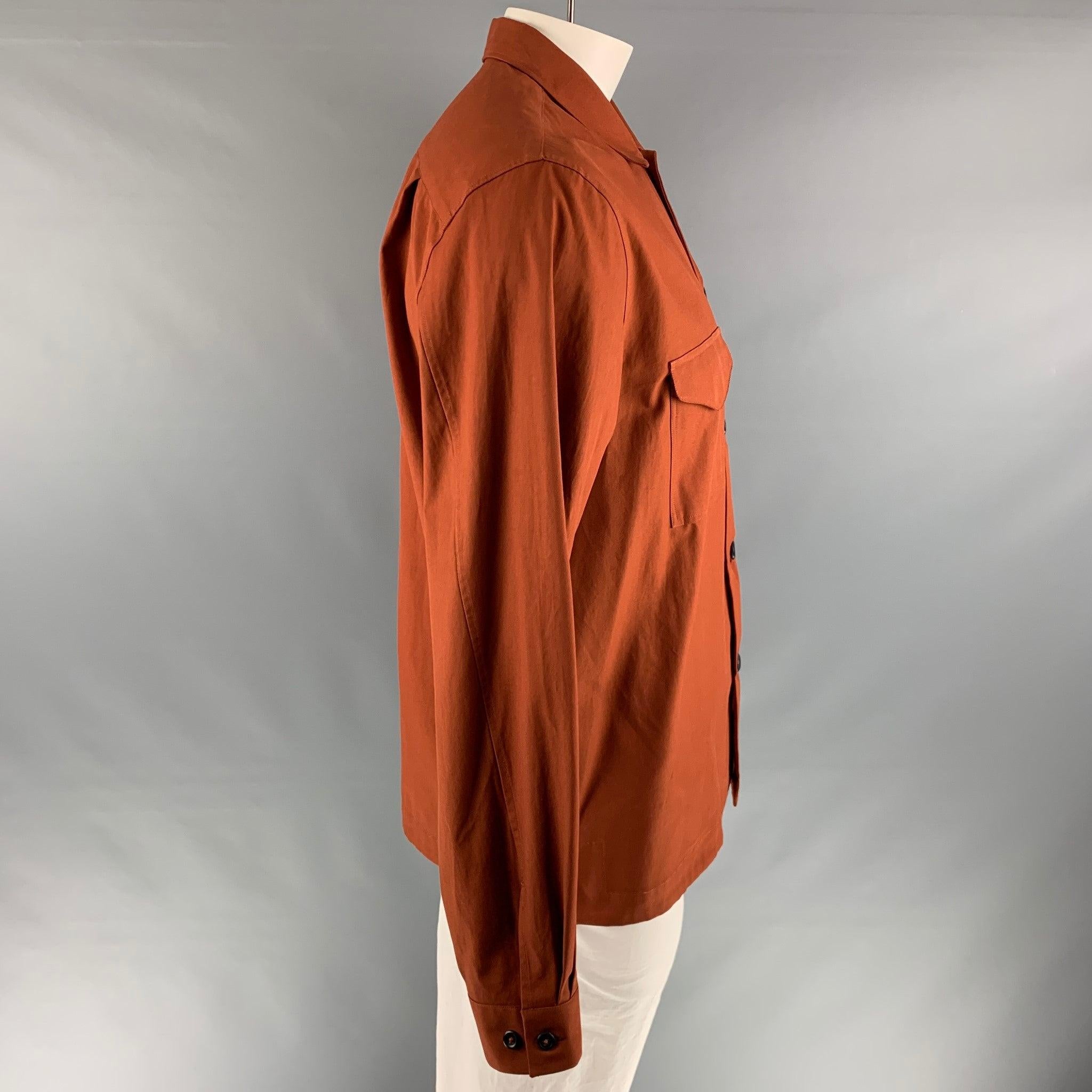 PAUL SMITH uniform style long sleeve shirt comes in a rustic orange cotton, featuring patch pockets, a button closure, and an oversized fit. Made in Italy.Very Good Pre-Owned Condition. 

Marked:   L 

Measurements: 
 
Shoulder: 19 inches Chest: 46