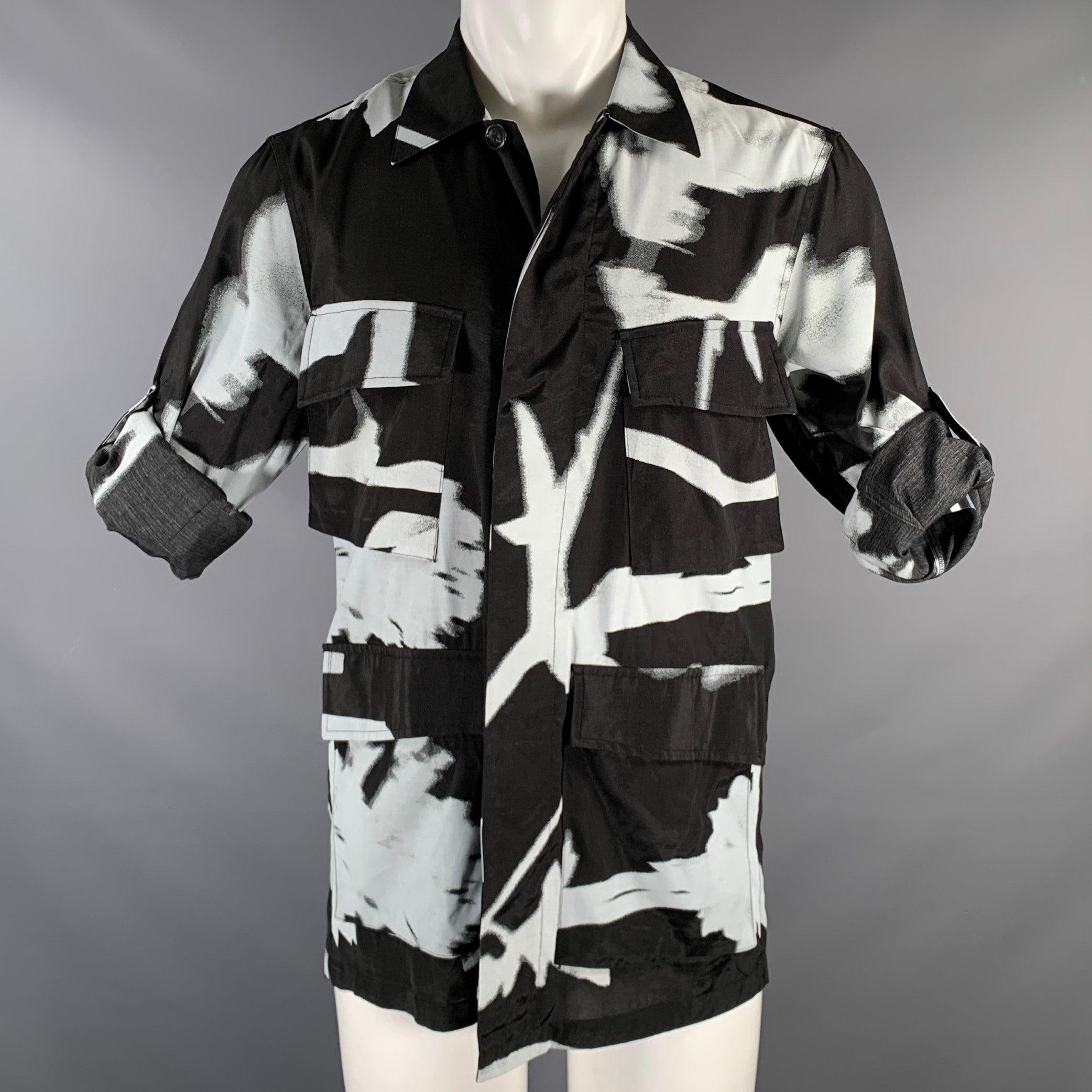 Veste PAUL SMITH
en viscose noire et blanche, avec un imprimé abstrait, quatre poches plaquées, des manches à pattes de boutonnage pour un look décontracté, et une fermeture à boutons. Fabriqué en Italie. Excellent état. 

Marqué :   S 

Mesures : 
