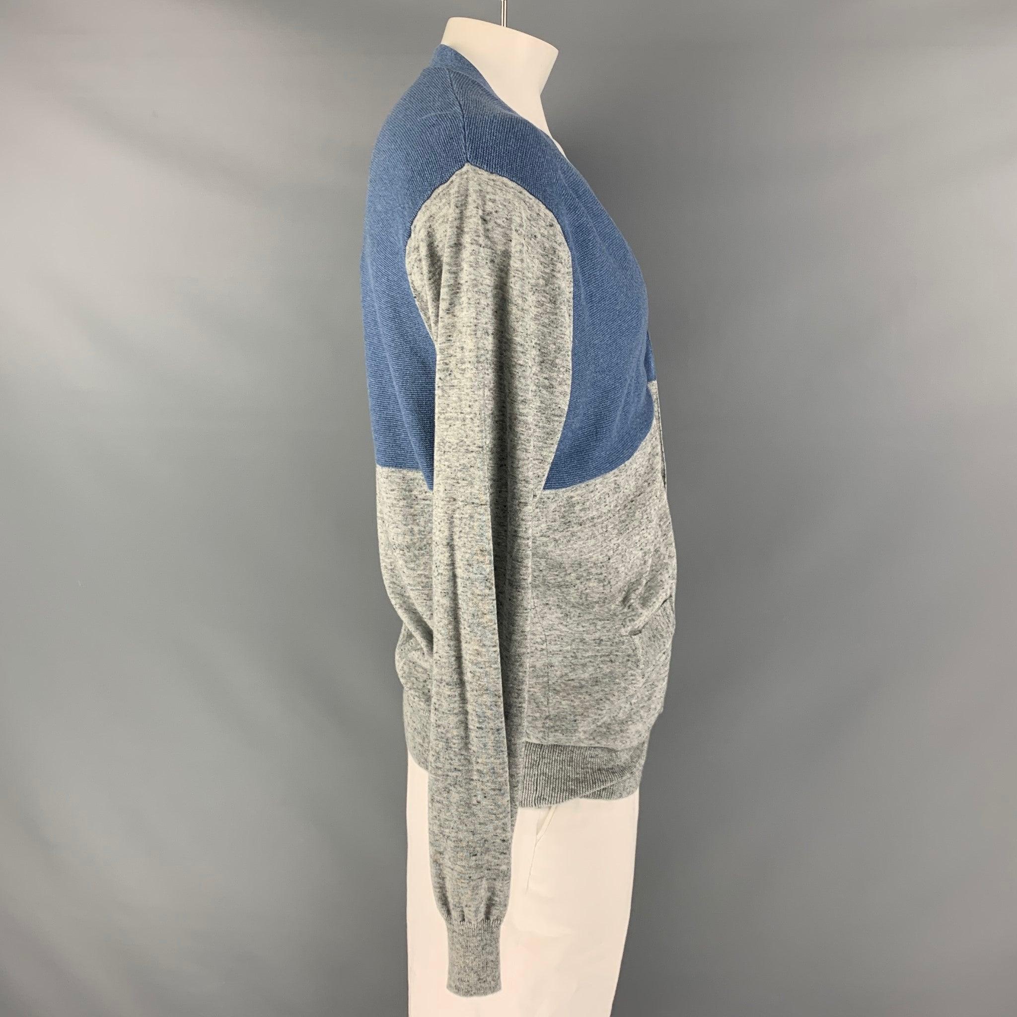 PAUL SMITH JEANS cardigan comes in a blue and grey color block cotton knit featuring a V-neck and frontal pockets. Very Good Pre-Owned Condition. 

Marked:   XL 

Measurements: 
 
Shoulder: 22 inches Chest: 50 inches Sleeve: 29 inches Length: 30