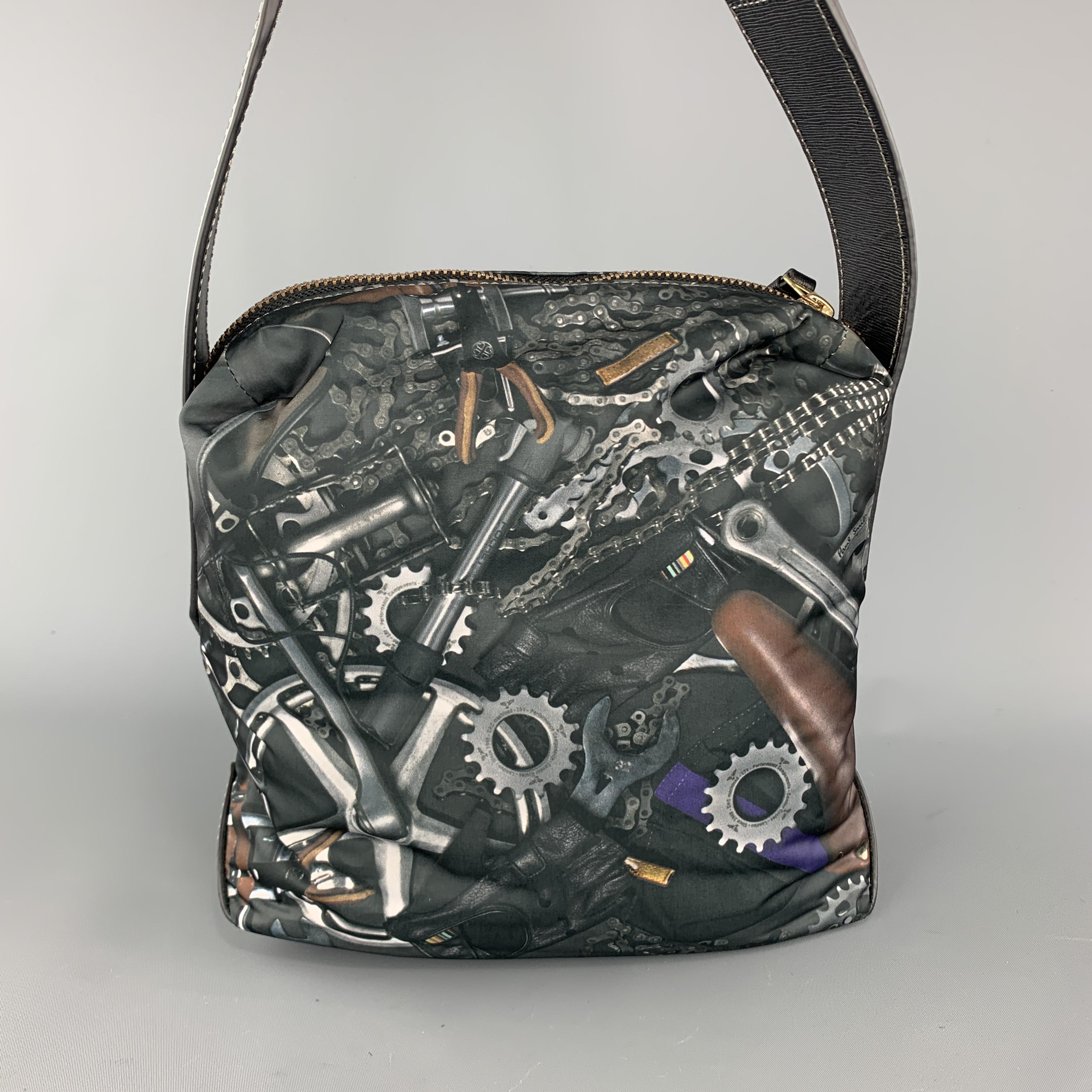 PAUL SMITH bag comes in slate gray tools print nylon with a top zip, textured leather details, and adjustable canvas crossbody strap. 

Excellent Pre-Owned Condition.

Measurements:

Length: 10 in.
Width: 5 in.
Height: 10 in.
Drop: 25 in.