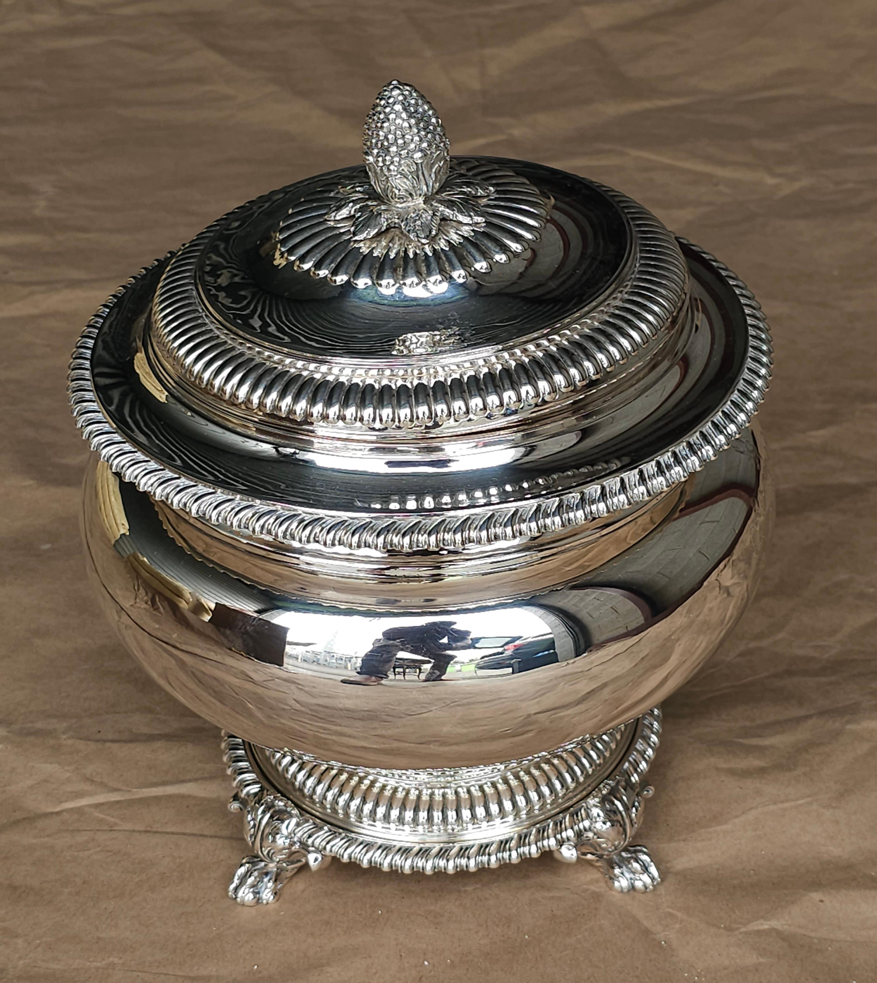 A museum quality George IV English Sterling Silver Covered Soup Tureen on Stand by
Paul Storr, London, Circa 1823
Lid engraved with 'Lion Rampant' herald; also repeated to the shoulder of the body with motto Nil Desperandum (Never Despair). Interior