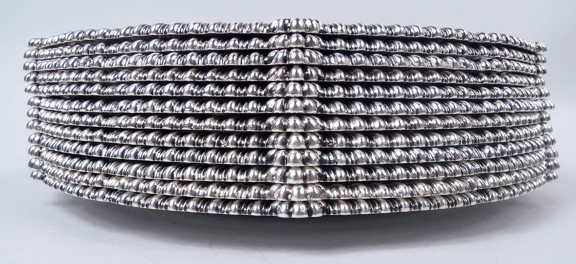 Ensemble de 12 assiettes à dîner en argent sterling de style géorgien anglais, 1810. Bordure serpentine godronnée entrecoupée d'anthemions. Armoiries gravées avec la devise latine 