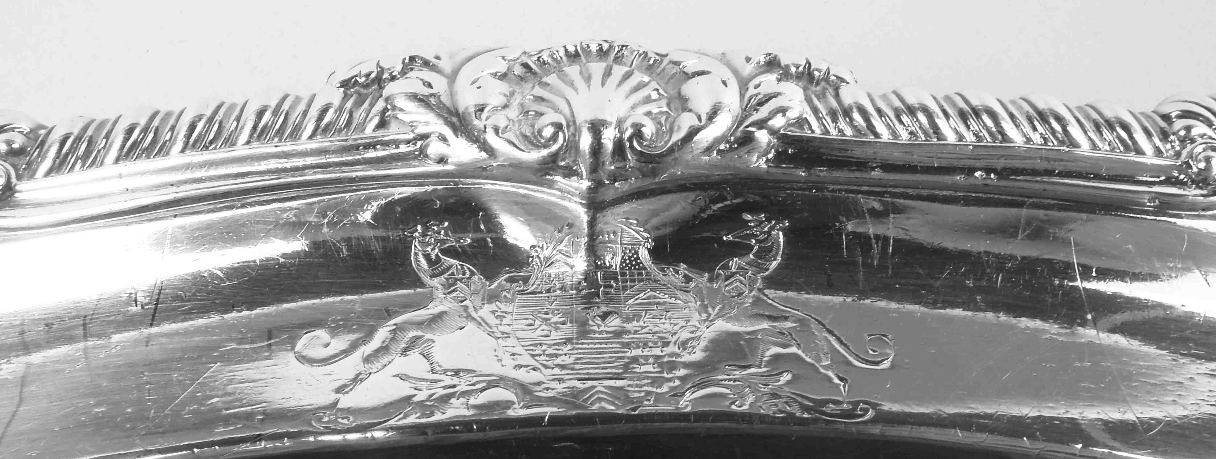 George III sterling silver sterling silver platter. Made by Paul Storr in London 1808. Oval well with serpentine shoulder and cast gadrooned rim interspersed with leaf-capped scallop shells and strapwork cartouches.

Superb craftsmanship as