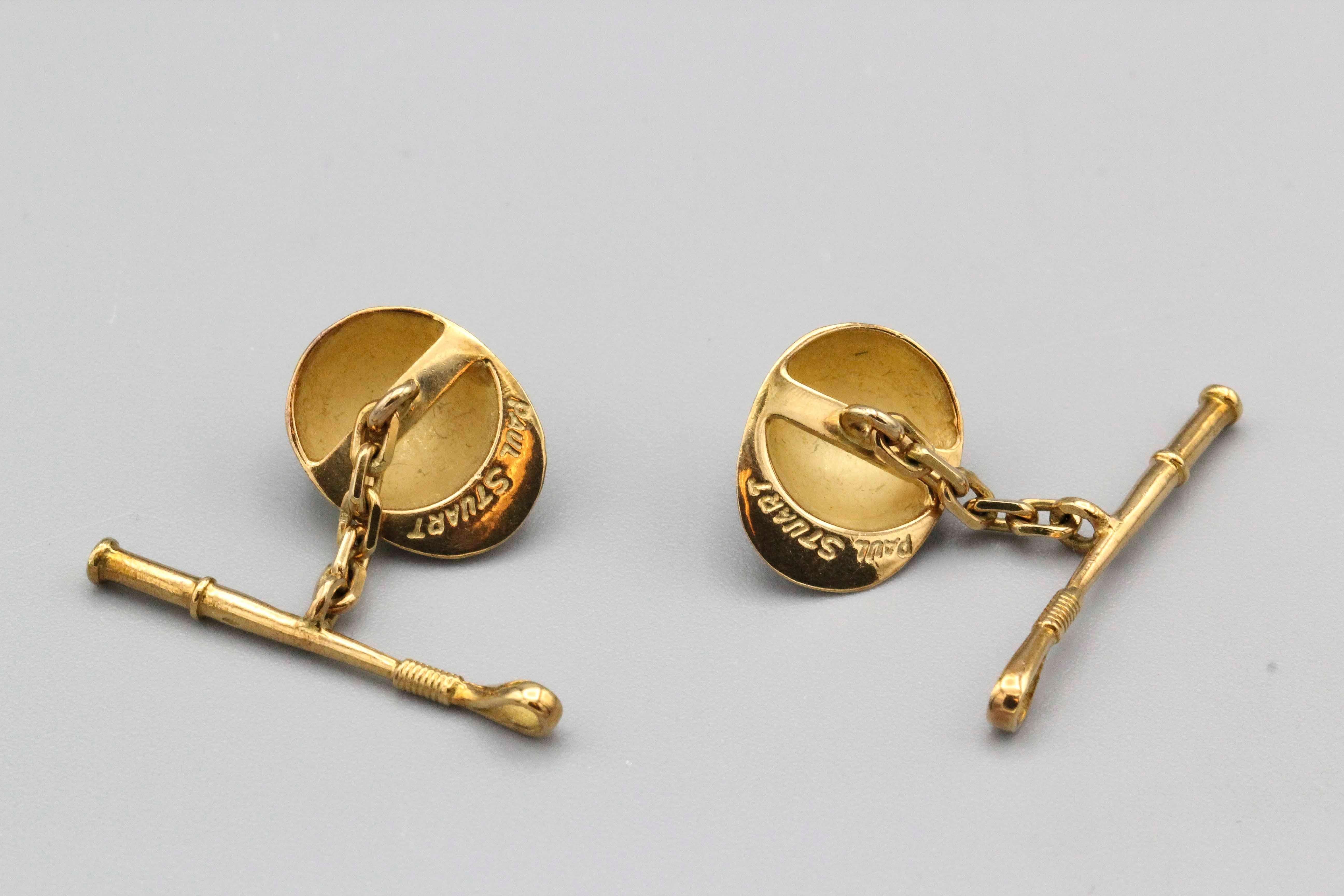 Fine pair of Paul Stuart 18k gold Equestrian motif cufflinks.  The cufflinks feature a yellow and blue enamel jockey hat on one end and a riding whip on the other. With original box.

Hallmarks: Paul Stuart, French 18k gold assay marks, maker's mark.