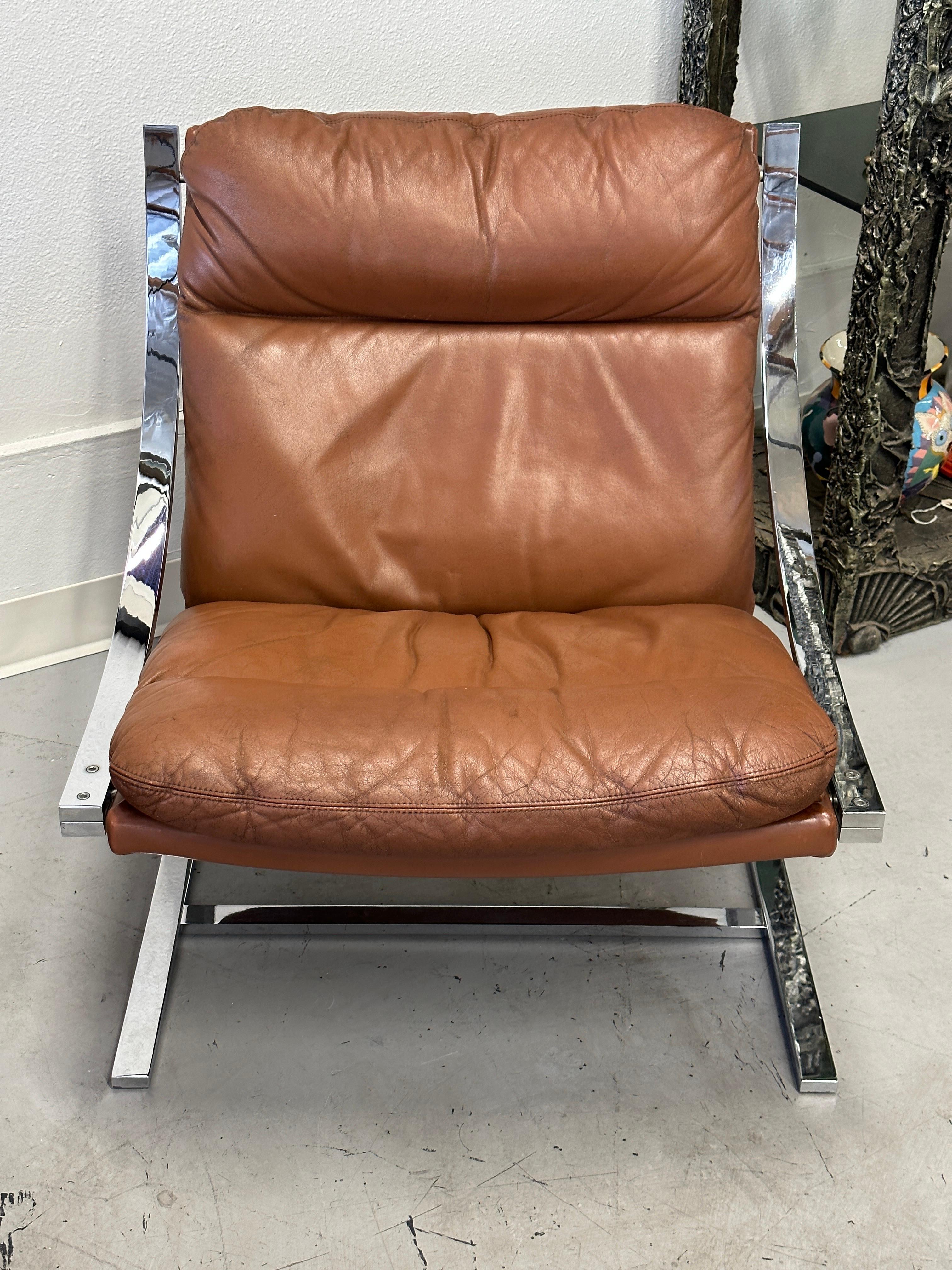 Nice pair of extremely comfortable lounge chairs in leather and chromed steel. Designed by Paul Tuttle for Strassle International these Zeta Collection chairs are in good overall vintage condition. One chair bears the original tag underneath,