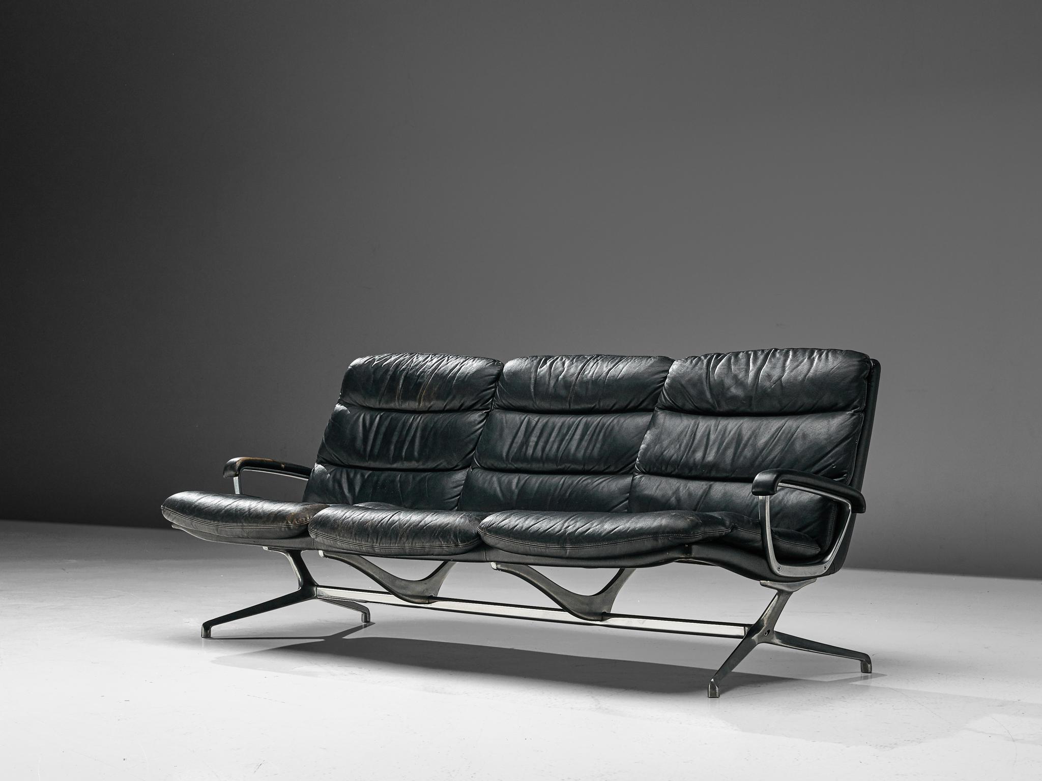 Paul Tuttle, three-seat sofa, for Strässle International, leather and cast aluminium, Switzerland, 1960s.

This sofa designed by Paul Tuttle is upholstered in black leather and has a striking aluminium frame an armrests, giving the sofa a very