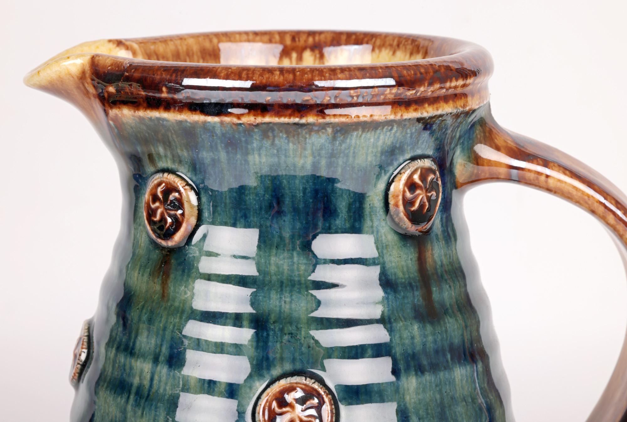 A tall and stylish British studio pottery jug made at Station Pottery by renowned potter Paul Young and dating from the latter 20th century. Paul Young is influenced by the work of many of the earlier Staffordshire potteries including Whieldon and