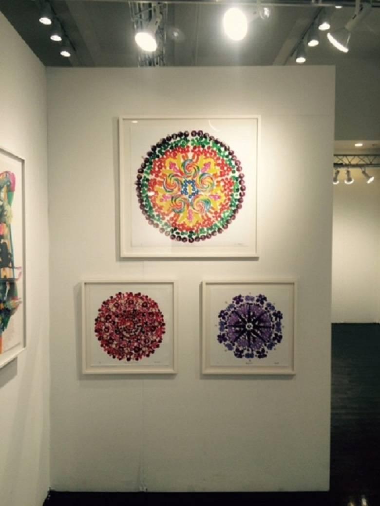 Diese Fotografien in limitierter Auflage sind Mandalas, die aus Bonbon- oder Eiscreme-Stücken, Spielzeug, Edelsteinen oder Früchten bestehen.  Das Mandala ist 20x20 mit einem weißen Rahmen in einer Größe von 24x24 gerahmt.  Er ist auch mit