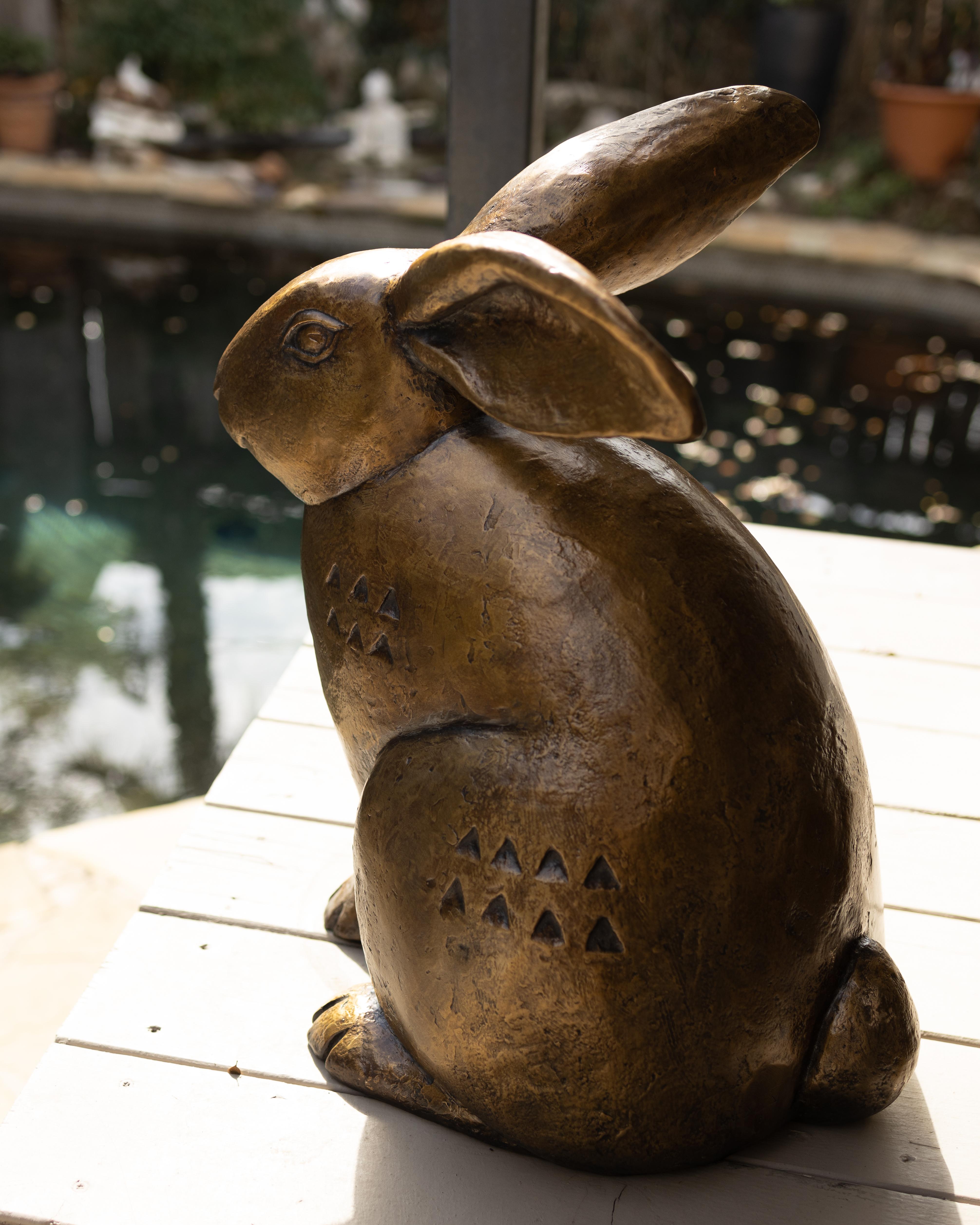 Cette exquise sculpture en bronze d'un lapin, créée par la célèbre sculptrice Paula Zima, mesure 21 x 13 x 20 pouces. Son design unique présente des indentations ornementales en forme de triangle sur les deux côtés, ce qui ajoute une texture