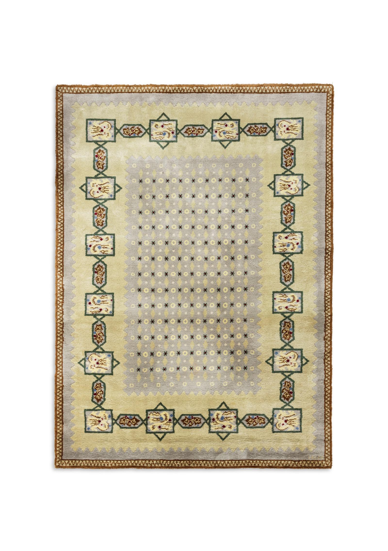 A rectangular knotted woollen rug with geometric decoration and stylized green and brown on a sky blue background. Signed in the frame.