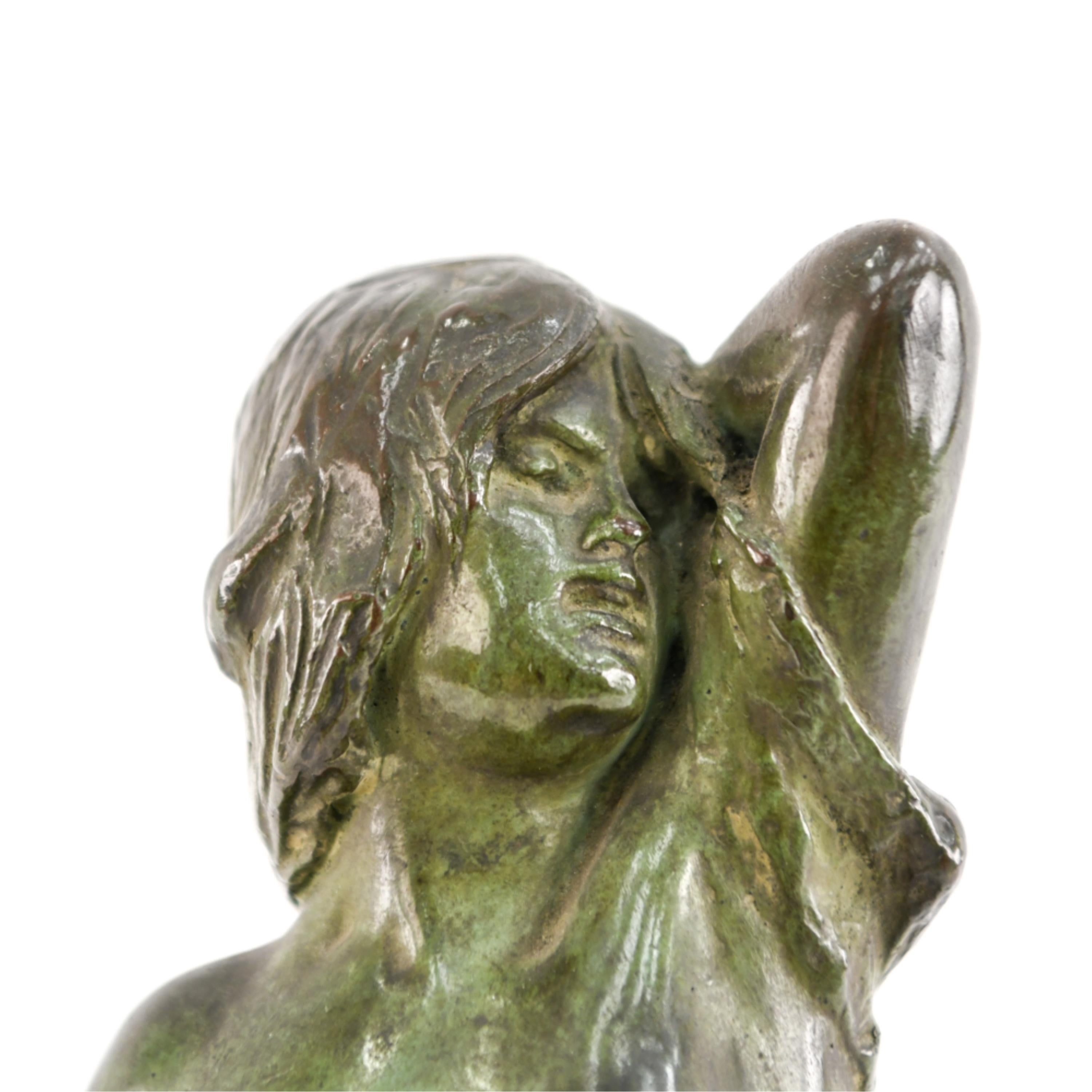 Il s'agit d'une intéressante sculpture en métal patiné représentant une femme nue. La base indique 