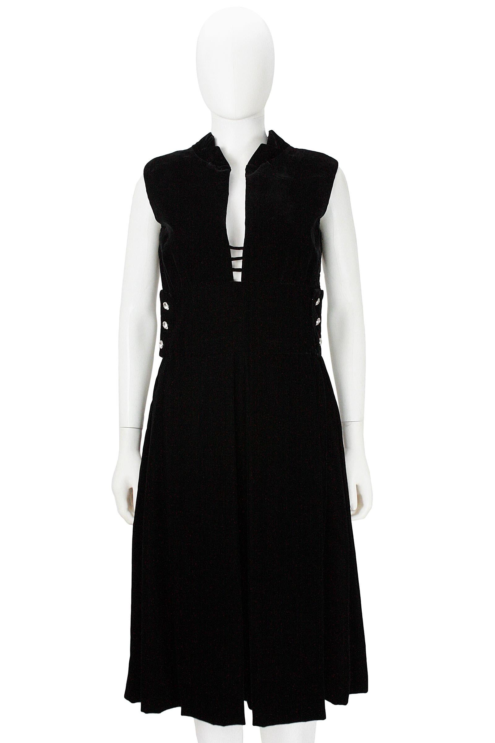 Pauline Trigere cocktail dress 
Black silk velvet 
V neck with small cutouts 
Center skirt pleat 
Rhinestone buttons 
Shoulder pads that could be removed 
Fully lined 
Side zipper closure 