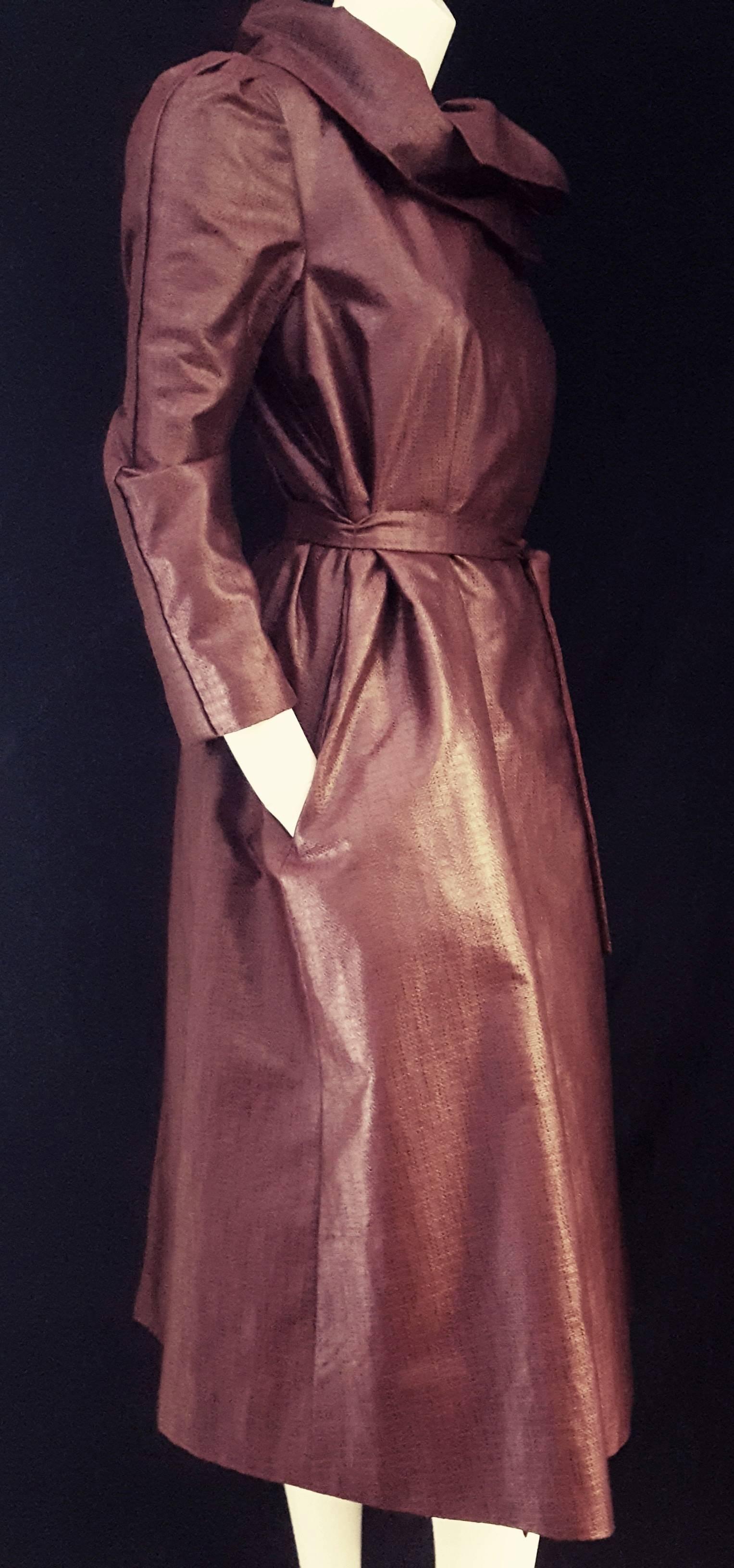 This vintage Pauline Trigere light weather coat is a combination of burgundy and black brocade and features an outstanding convertible collar with 3 buttons that can be worn open or closed for 2 different effects.  The coat is made of a light fabric