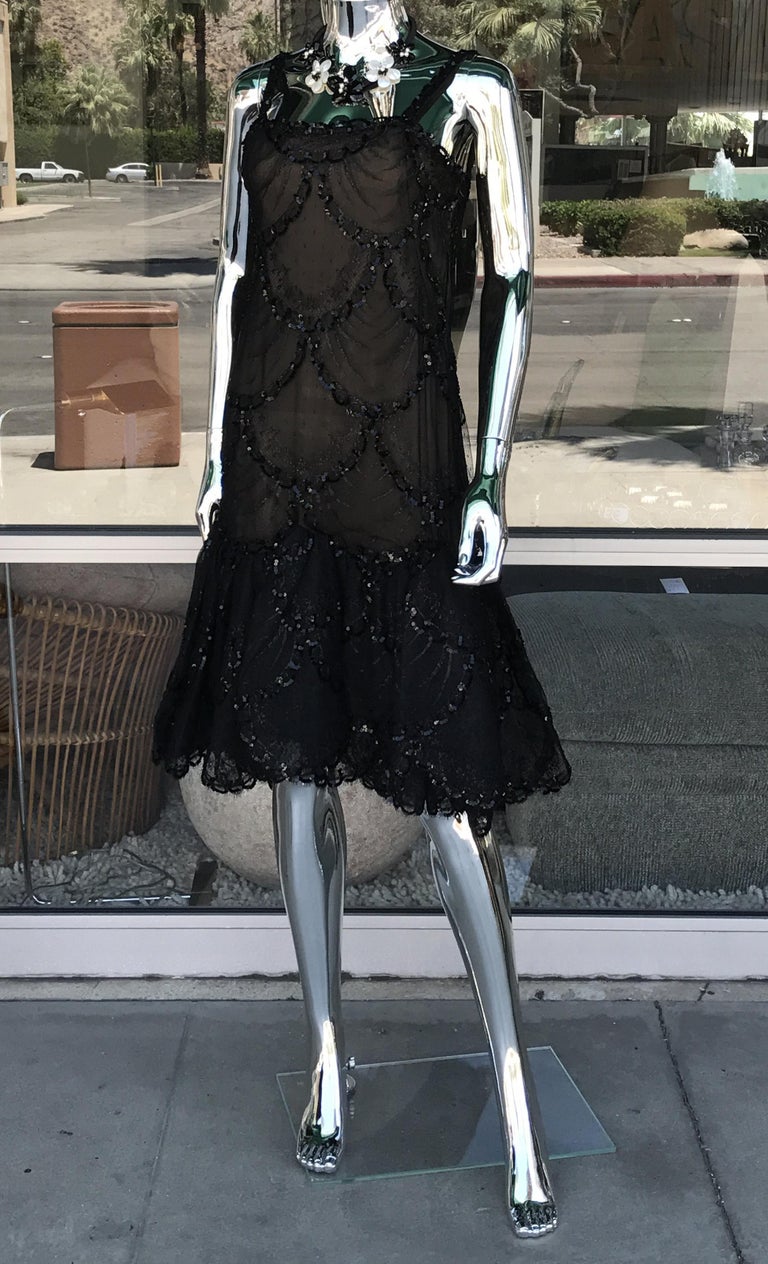 A gorgeous cocktail dress by the legendary Pauling Trigere. In hand beaded tulle and lace, the flirty dress is entirely lined in nude silk chiffon. This couture dress is a true work of art. I believe it's a size 6.