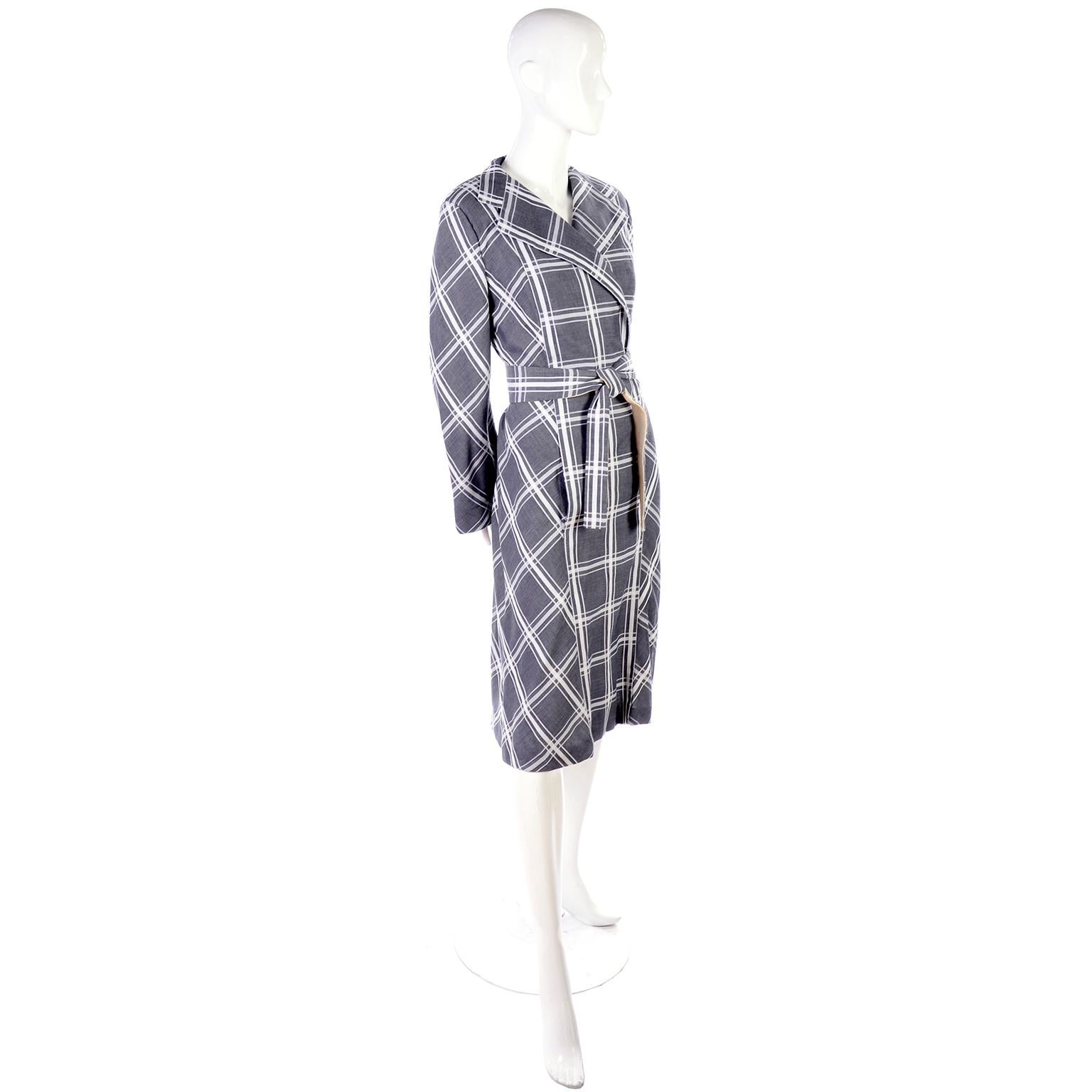 This is a lovely Pauline Trigere vintage coat dress in charcoal gray and white thick cotton plaid.  The long sleeves flair at the ends. The dress is closed at the bottom and the top secures with two hook and eyes. The tie waist belt is lined in