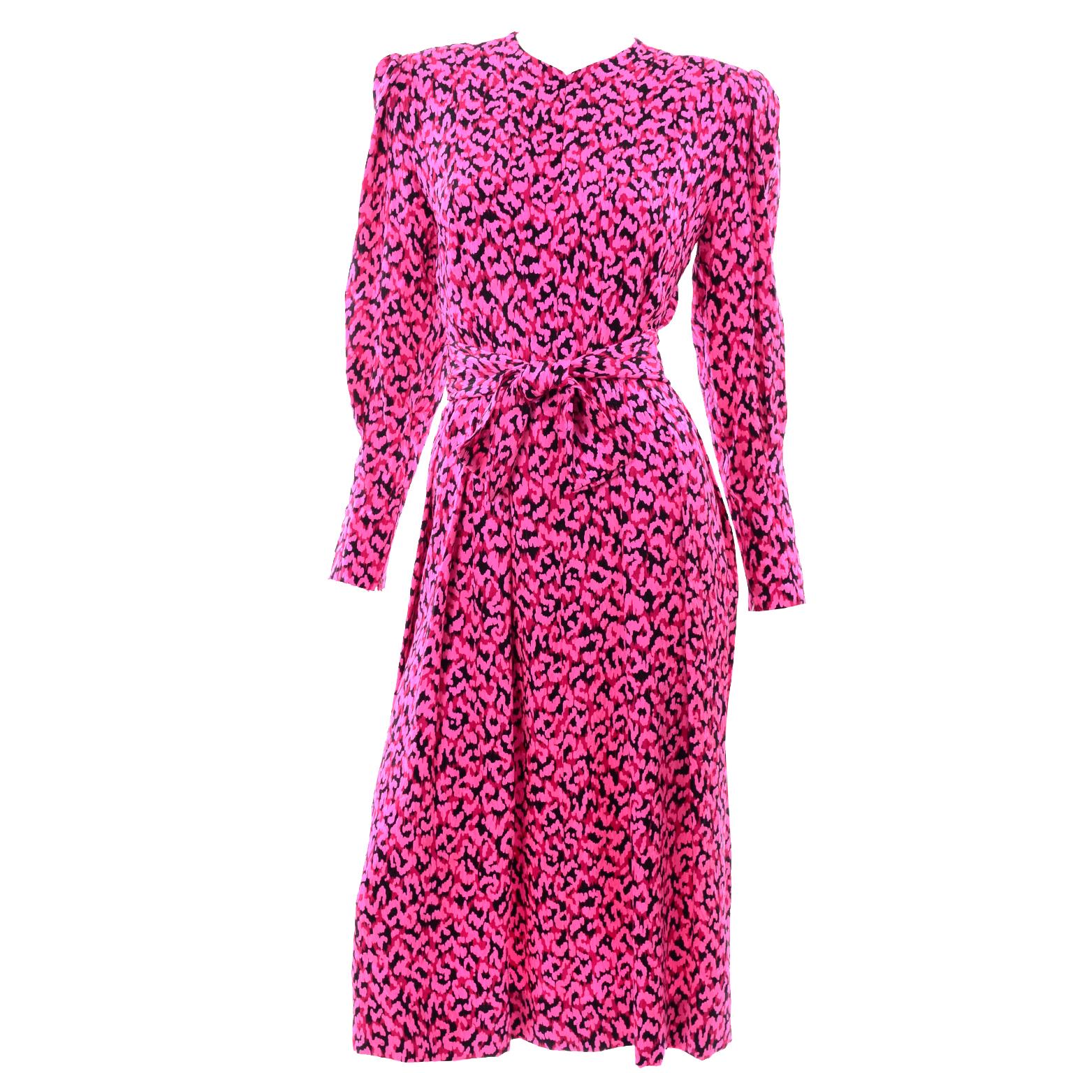 This is a vintage Pauline Trigere pink, red and black abstract print long sleeve silk dress. The dress has puff sleeves with slim zippered cuffs hat have the same pleats found on the rest of the dress  High v-neckline and boxy shoulder pads. The