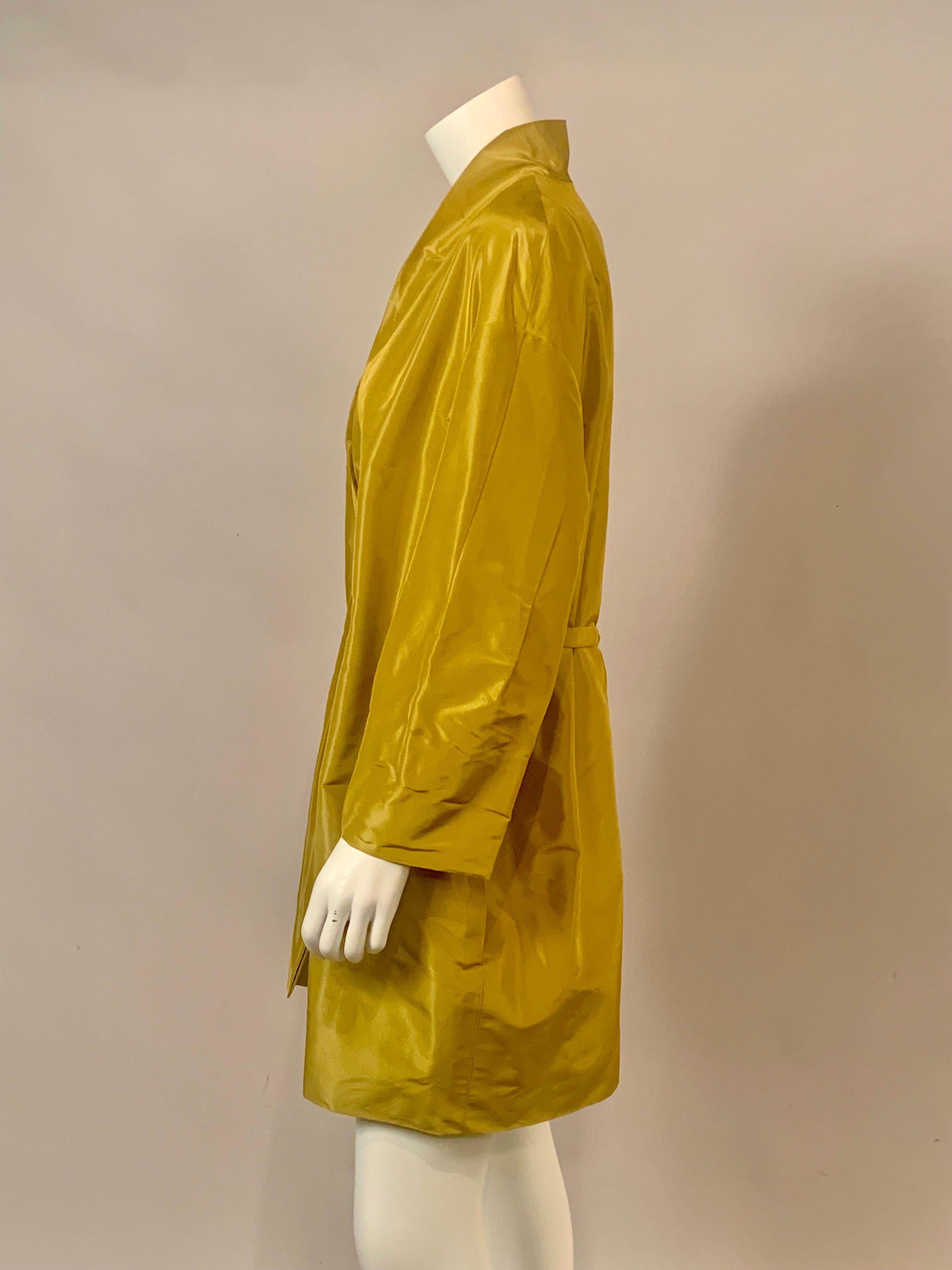This eye catching chartreuse silk coat from Pauw, Amsterdam definitely makes a statement.  The collarless coat has a pleated and gathered center front with two interior ties which slide through openings on either side and tie at the center back.