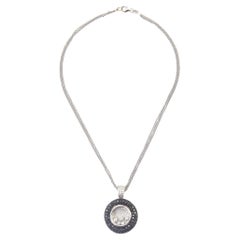 Collier pendentif circulaire en or blanc avec diamants noirs et blancs pavés