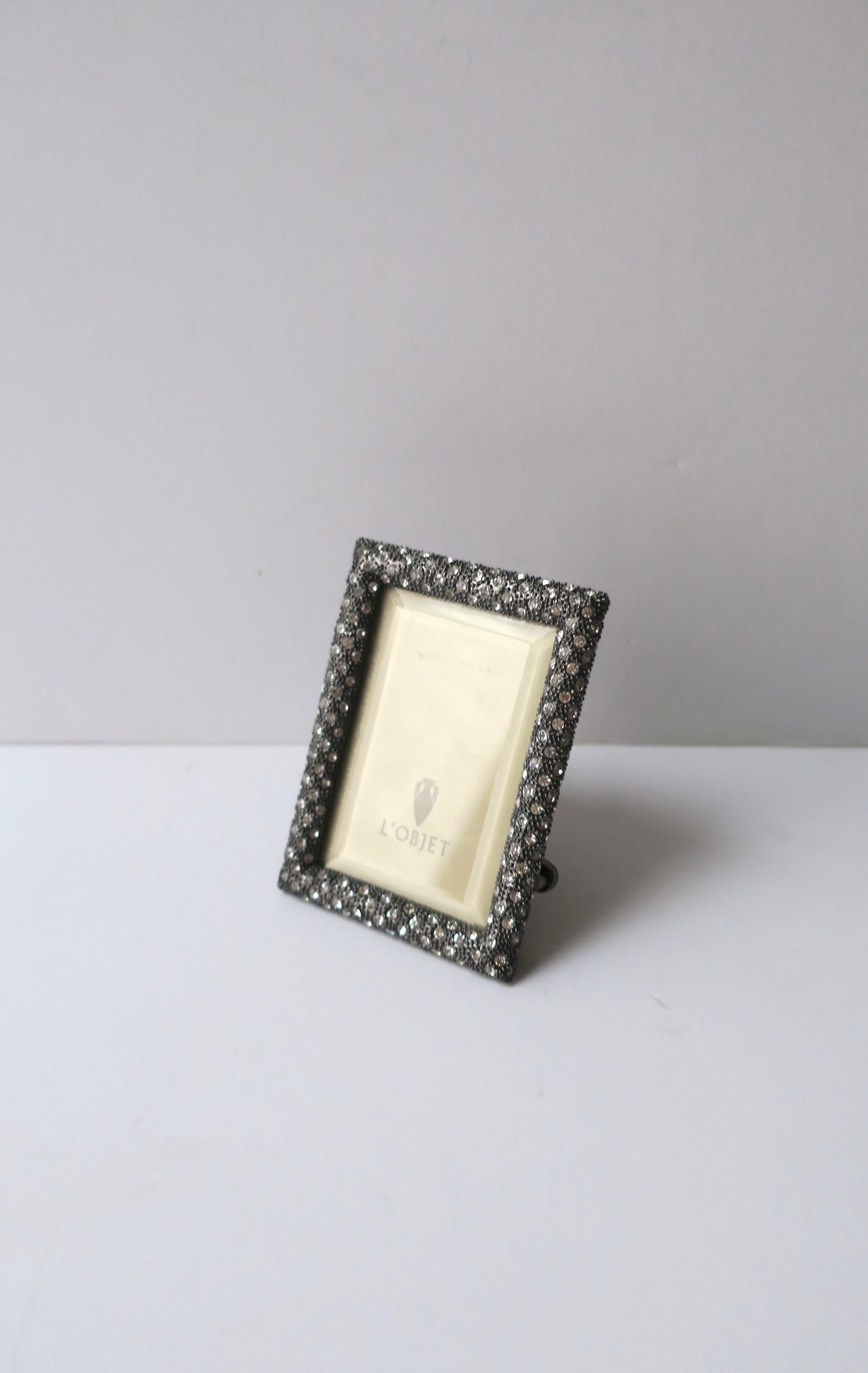 A very beautiful and substantial rectangular picture frame carefully designed and handcrafted with platinum plating, pave set clear/transparent Swarovski crystals, and beveled glass. Dimensions: 2.63