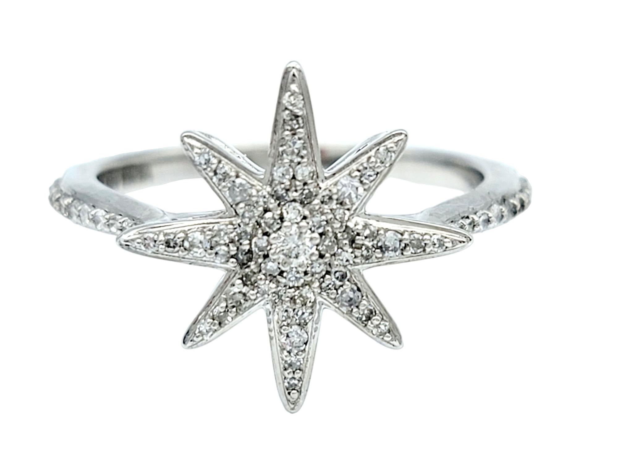 Ring size: 7

This gorgeous 14 karat white gold ring boasts an exquisite design, featuring an captivating 8-point star adorned with pavé-set diamonds. This central motif immediately captures the eye with its intricate brilliance, emanating a