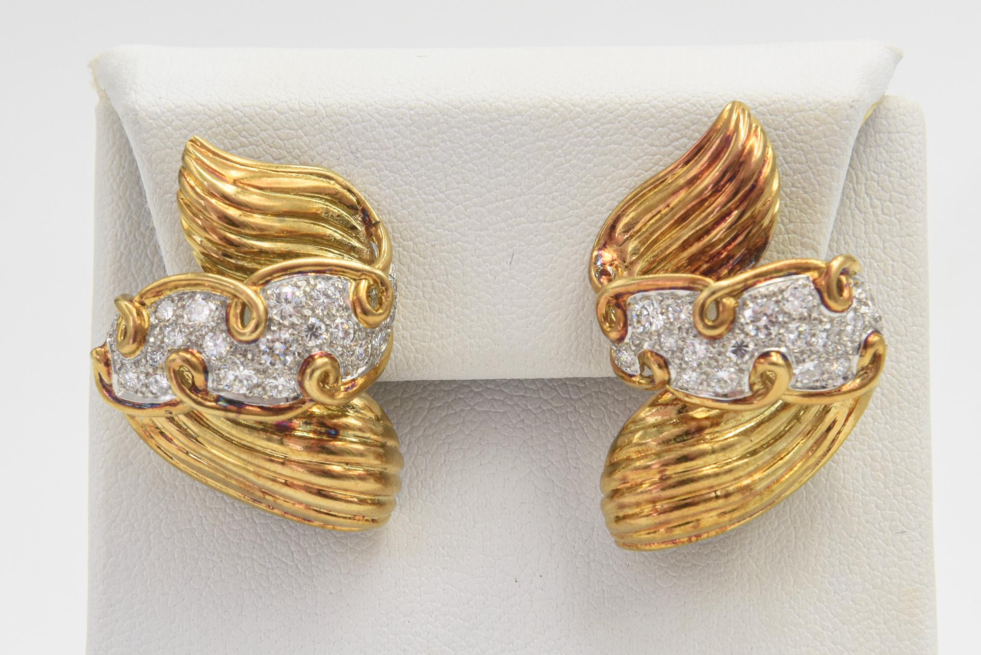 Gorgeous three dimensional ribbon earrings featuring a fluted gold design with a pave diamond center section. These 18k yellow gold earrings contain approximately 2.50 carats total weight in diamonds.  They have a lever back with a post so pierced