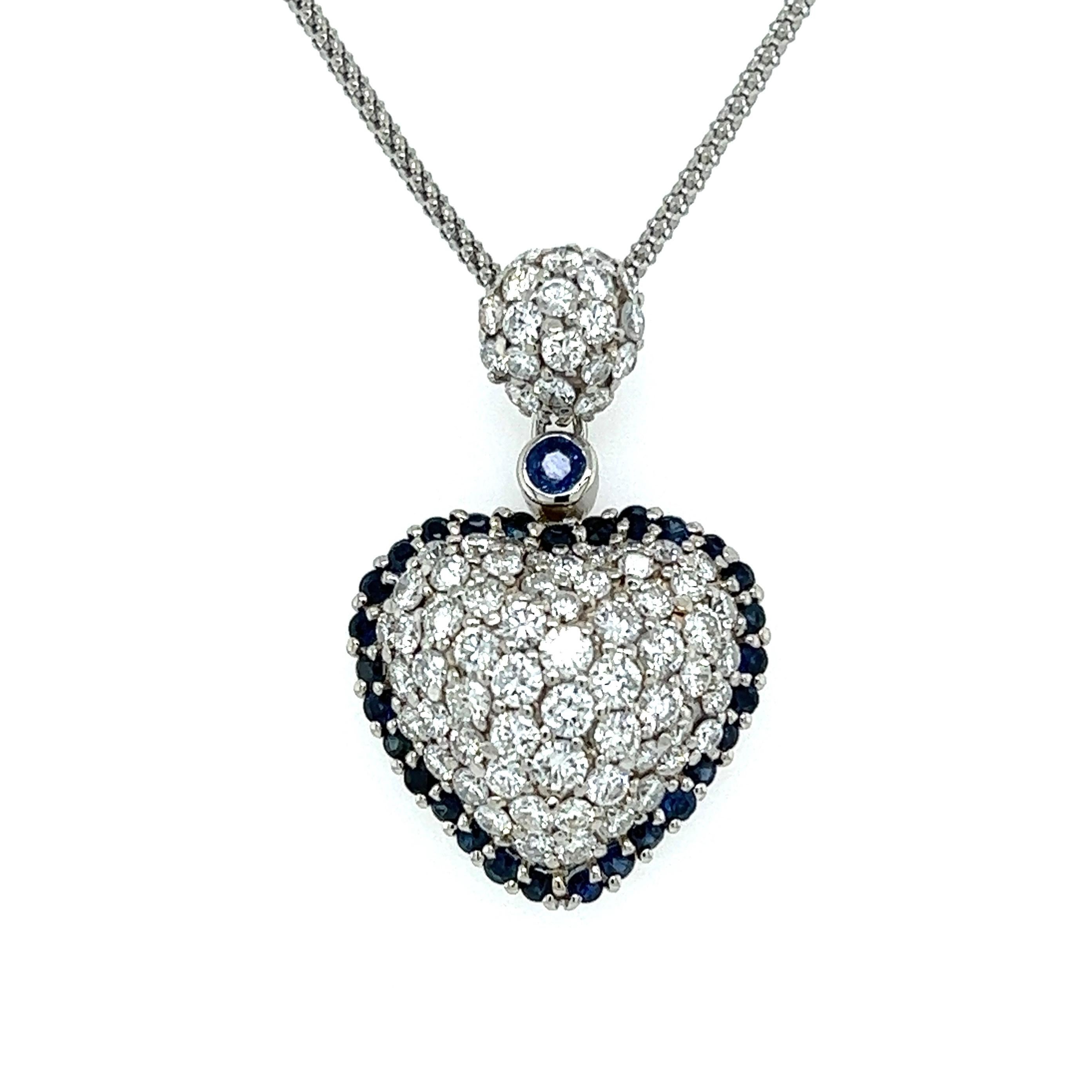 Simply Beautiful! Finely detailed Diamond and Sapphire Halo Heart Platinum Pendant Necklace. Centering Pave Hand set Diamonds, weighing approx. 2.65tcw, surrounded by Blue Sapphires, approx. 0.95tcw. Pendant size: 1.25” l x 0.80” w. Hand crafted in