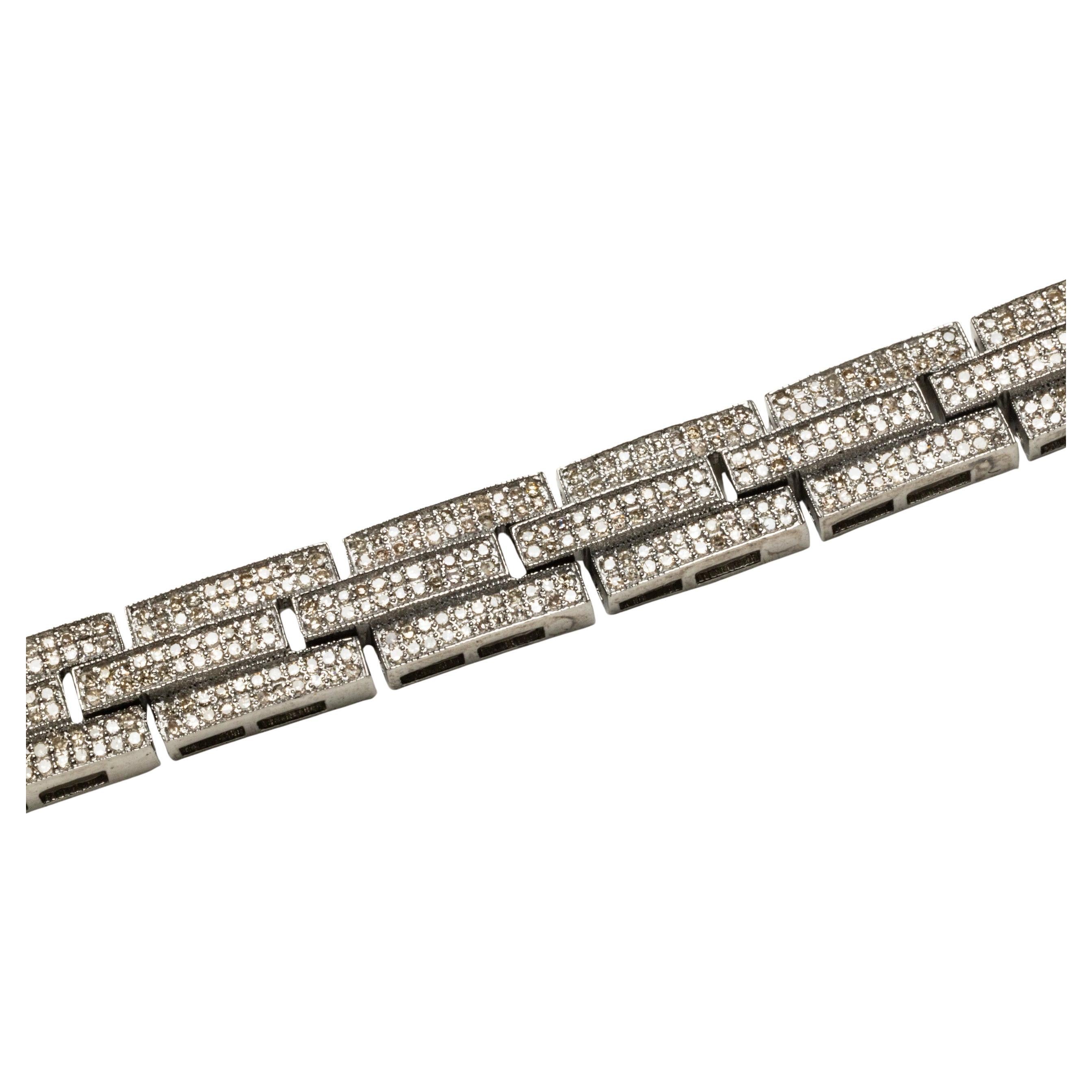Preciosa pulsera de eslabones de diseño geométrico engastada con multitud de diamantes redondos de talla brillante en engaste pavé.  Engarzado en plata de ley.  Cierre a presión con dos seguros laterales.  El peso total en quilates de los diamantes