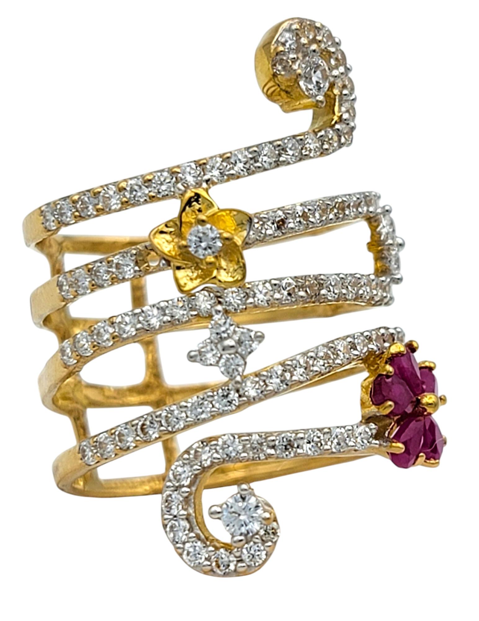 Ring Size: 6

Make a whimsical statement with this uniquely sculptural ruby and diamond ring. Designed with a coiled, modern silhouette in rich 22 karat yellow gold, the ring showcases a vibrant pear-shaped ruby blossom accented by a sparkling coil