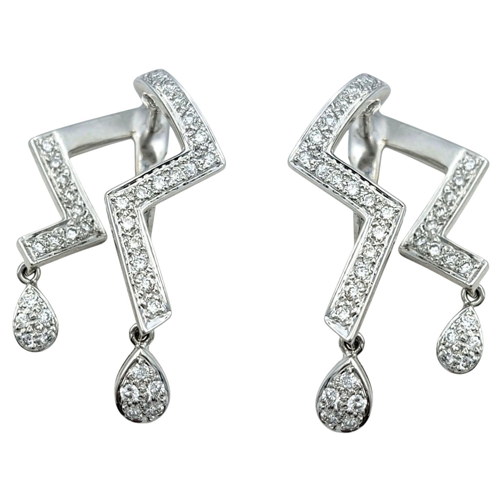 Fusion frappante de l'élégance contemporaine et de l'art géométrique, ces boucles d'oreilles en diamant sont un ajout captivant à toute collection de bijoux. Réalisées en or blanc 18 carats lumineux, ces boucles d'oreilles présentent un design en