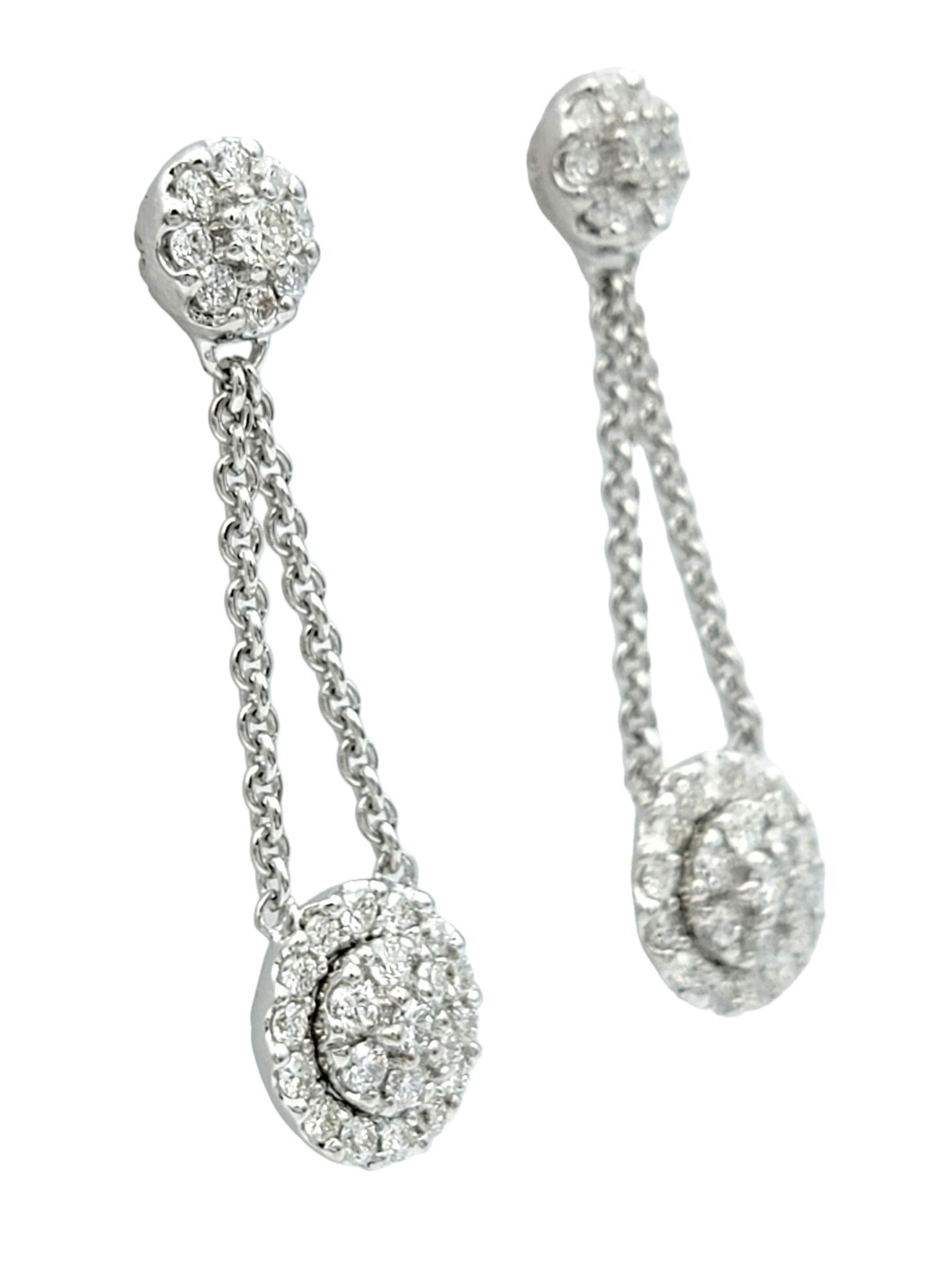 These gorgeous diamond earrings, set in 18 karat white gold, are a timeless expression of elegance and sophistication. At the center of each earring lies a dazzling diamond cluster, exuding brilliance and capturing the light with every movement.