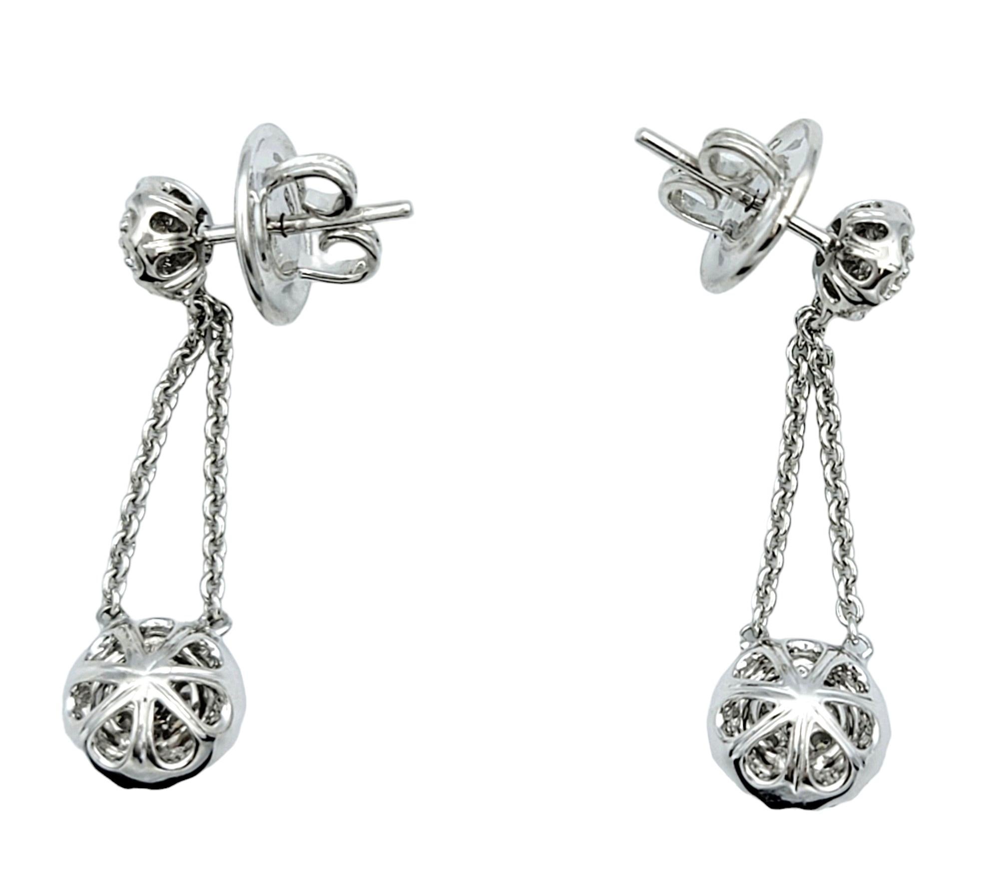 Round Cut Pavé Diamond Halo Dangling Drop Earrings Set in Polished 18 Karat White Gold For Sale