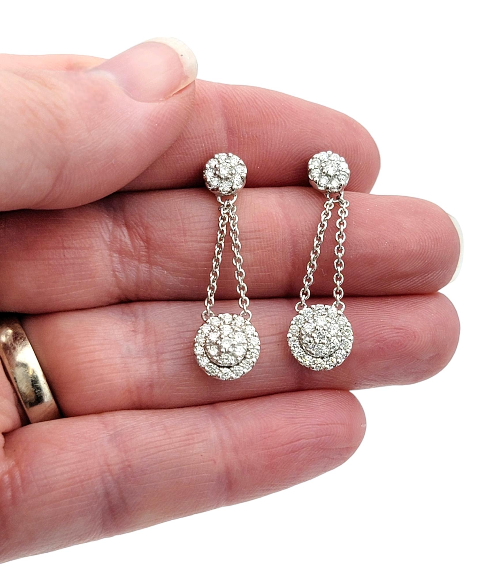 Women's Pavé Diamond Halo Dangling Drop Earrings Set in Polished 18 Karat White Gold For Sale