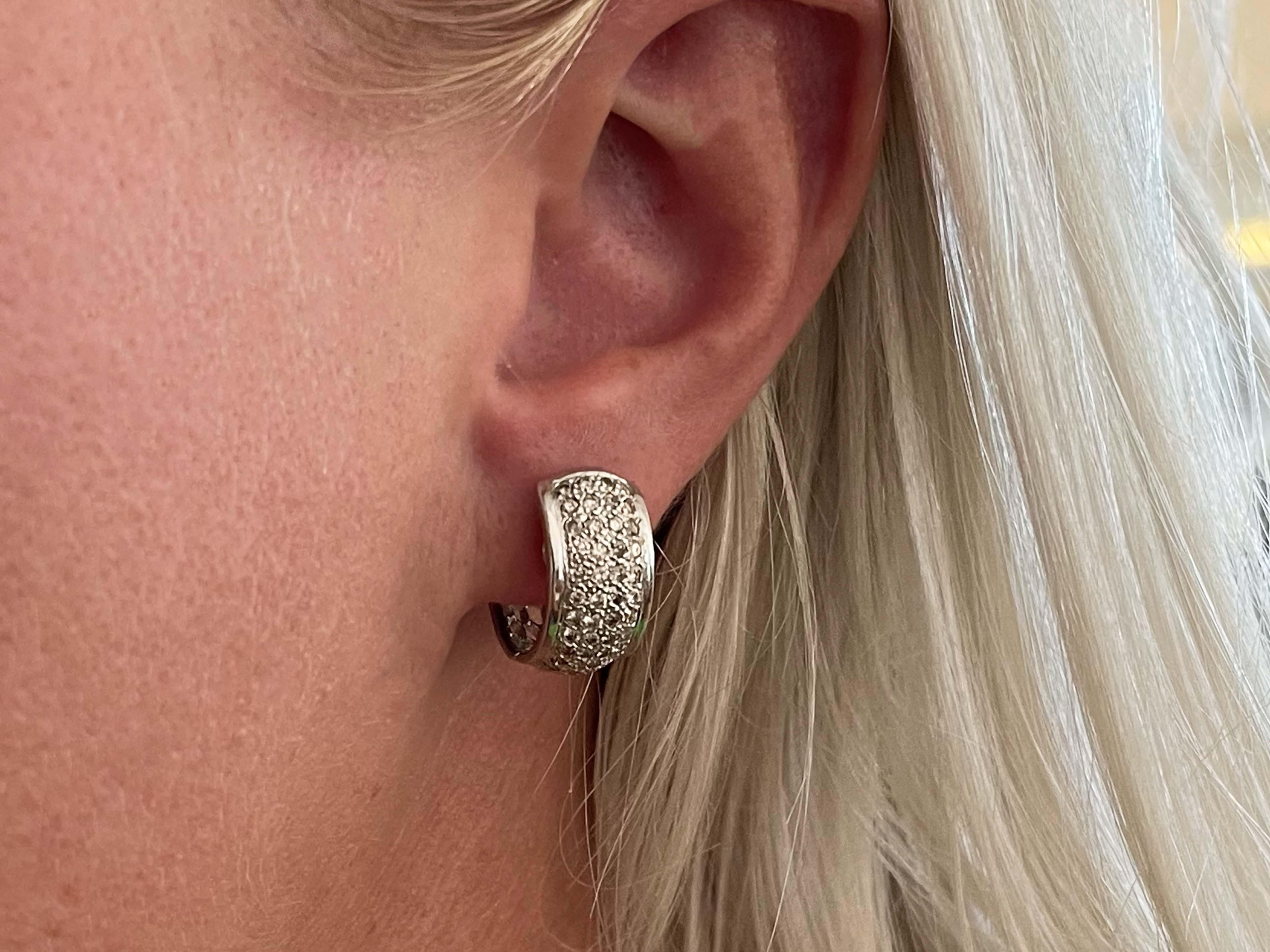 Crafted in 18K white gold, 44 round brilliant cut diamonds are pave set on each hoop creating endless sparkle. The diamonds are white and champagne in color and SI1-I1 in clarity totaling approximately 0.75 carats. These magnificent hoop earrings