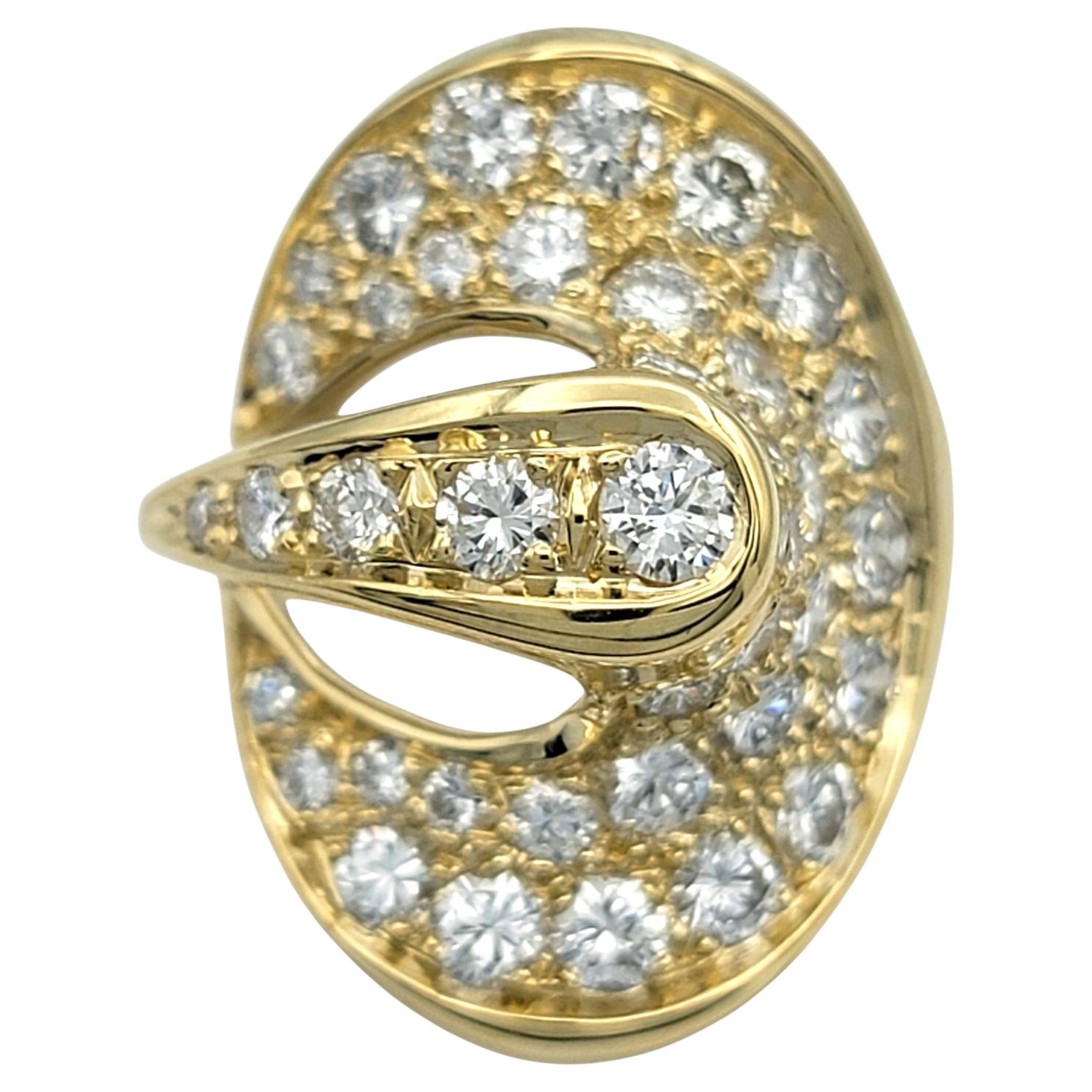 Este impresionante anillo de diamantes muestra un intrincado diseño en espiral que irradia movimiento y sofisticación. Una ola de deslumbrantes diamantes se curva con gracia por la parte superior, encontrándose en un escultural detalle cruzado que