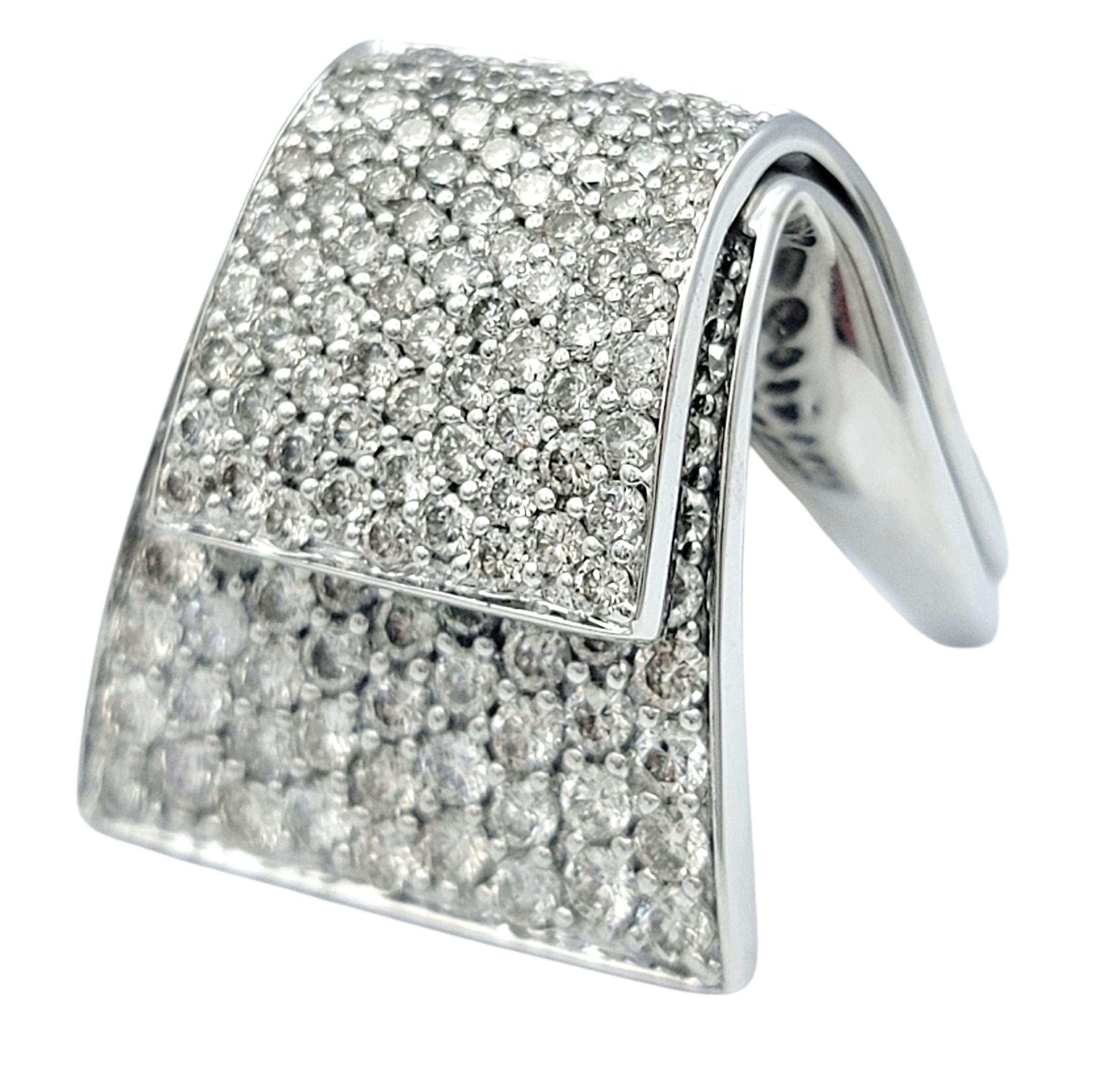 Dieser atemberaubende Diamantring ist aus 14 Karat Weißgold gefertigt und mit einem zeitgenössischen Überlappungsmotiv aus runden Brillanten besetzt. Die Oberfläche ist dicht mit Pavé-Diamanten besetzt, die ein elegantes, durchgehendes Funkeln auf