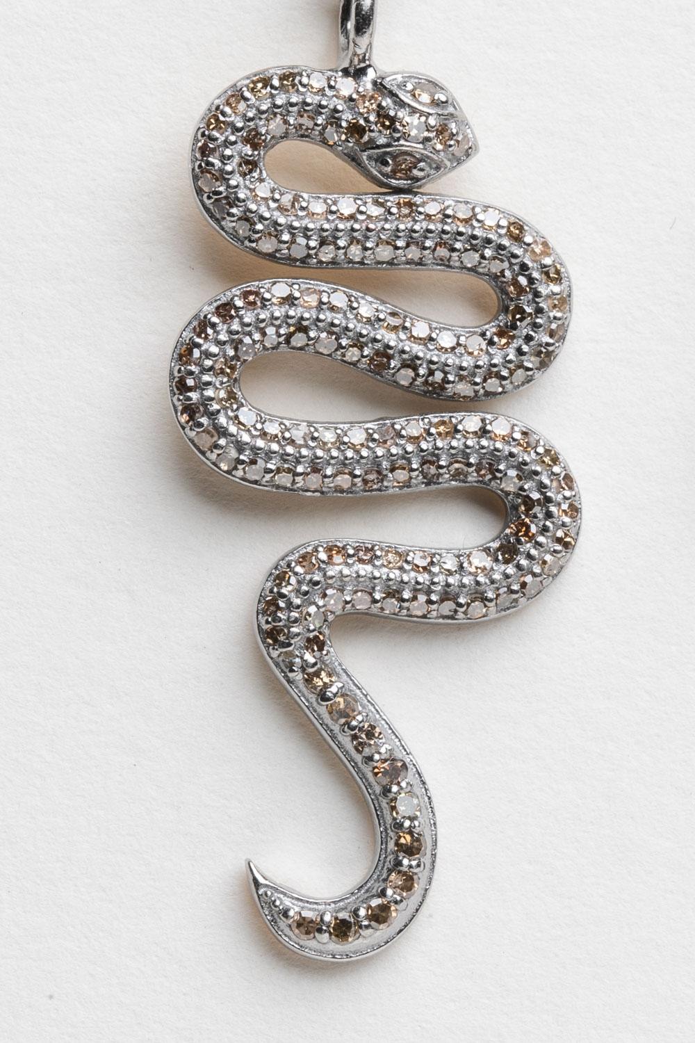 A lively pair of snake earrings comprised of round, brilliant cut and champagne diamonds in a pave` sterling silver setting.  18K gold post for pierced ears.  Diamonds total .82 carats.