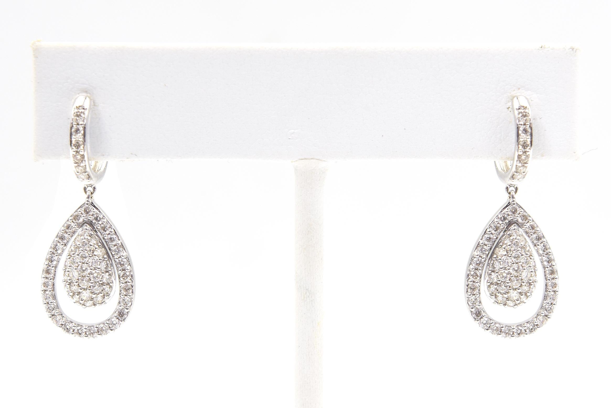 Orecchini di diamanti in oro bianco 18 carati con un cerchio di diamanti all'orecchio e una goccia di diamanti in pavé che penzola all'interno di una montatura di diamanti a forma di pera.  Il peso totale approssimativo dei diamanti è di 1,27 dwt.