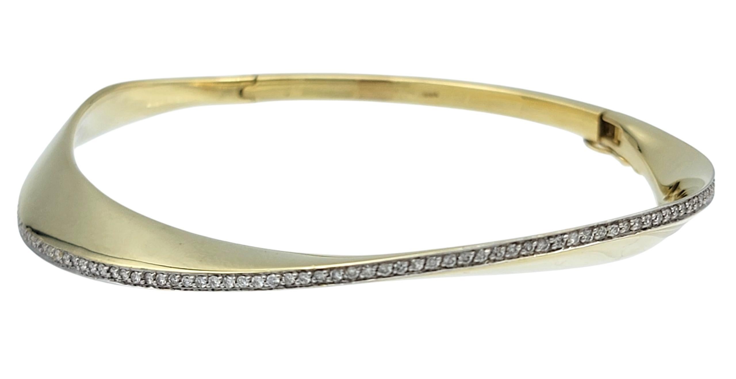 Bracelet bangle contemporain au design unique, avec une vague de diamants. Ce magnifique bracelet est fabriqué en or jaune 14 carats poli et comporte une ouverture latérale à charnière. La moitié supérieure du bracelet présente un design moderne en